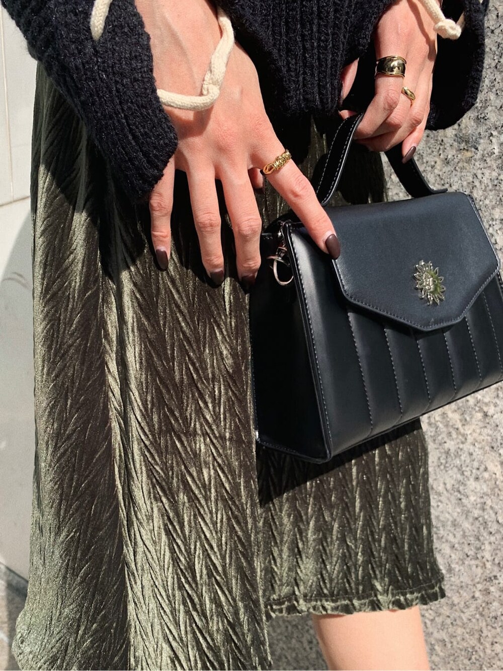 ブラック系のニット/セーター、ブラック系のショルダーバッグ、ベージュ系のワンピースを着用したレディースの冬コーディネートの7枚目の写真