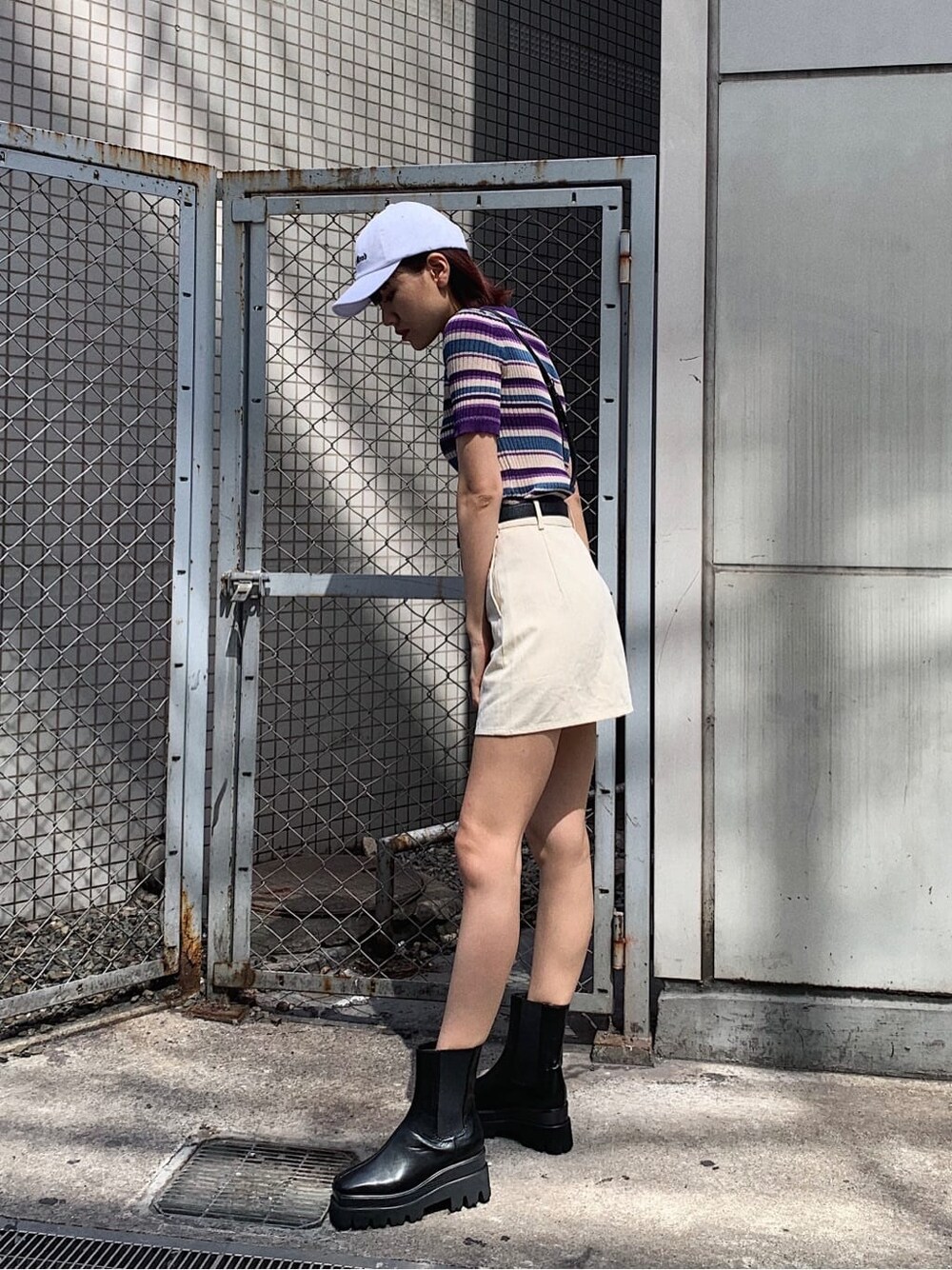 ブラック系のショルダーバッグ、ホワイト系のスカート、パープル系のニット/セーターを着用したレディースの春コーディネートの3枚目の写真