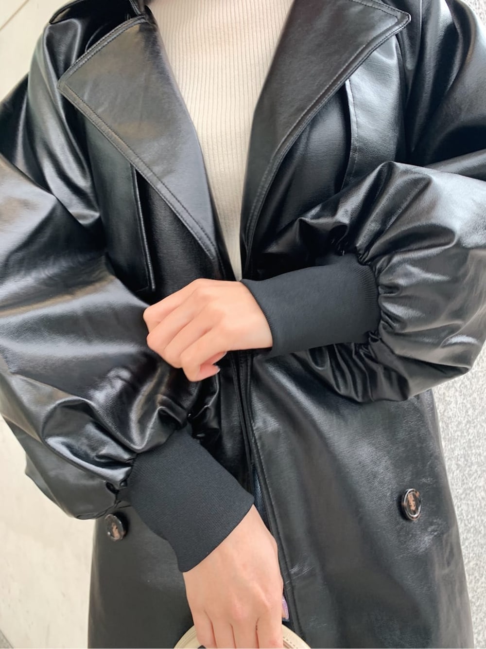 ホワイト系のニット/セーター、ベージュ系のブーツ、ブラック系のトレンチコートを着用したレディースの冬コーディネートの4枚目の写真