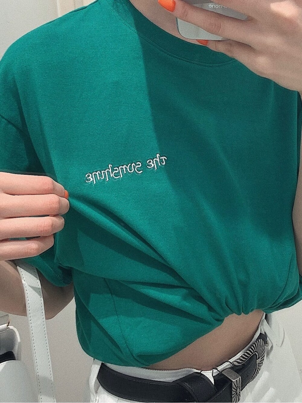 ブラック系のスニーカー、ホワイト系のショルダーバッグ、ホワイト系のデニムパンツを着用したレディースの春コーディネートの4枚目の写真