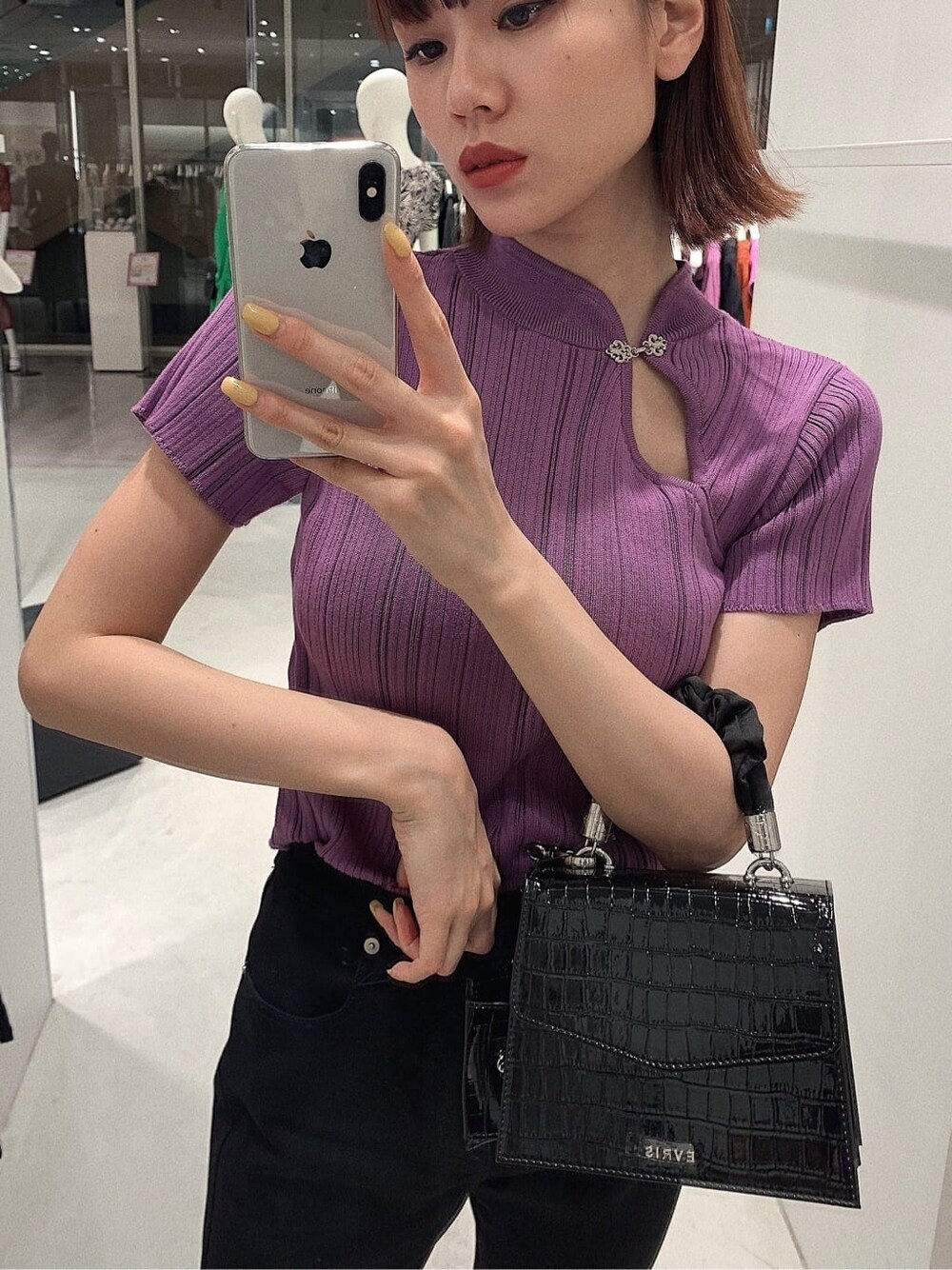 ブラック系のパンプス、ブラック系のデニムパンツ、パープル系のニット/セーターを着用したレディースの春コーディネートの2枚目の写真