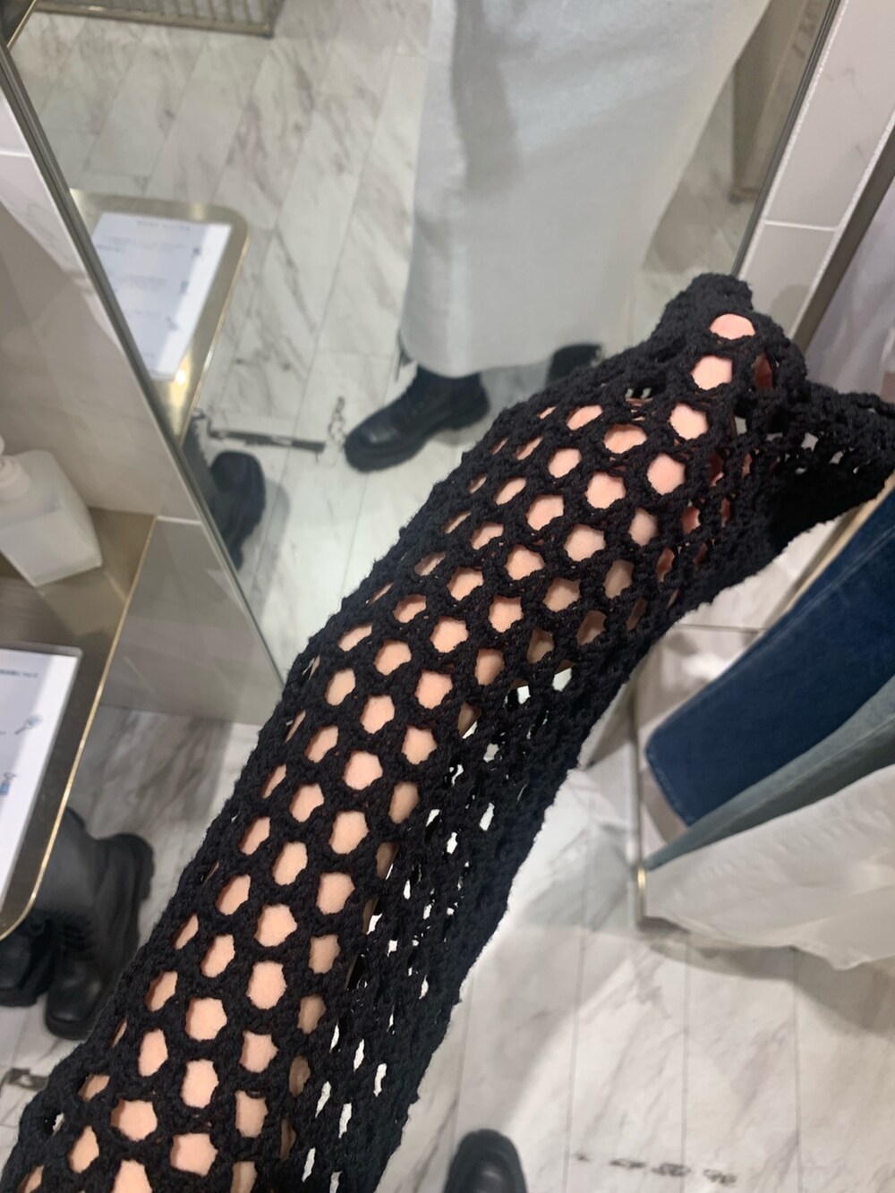 グレー系のワンピース、ブラック系のニット/セーター、ブラック系のブーツを着用したレディースの春コーディネートの4枚目の写真