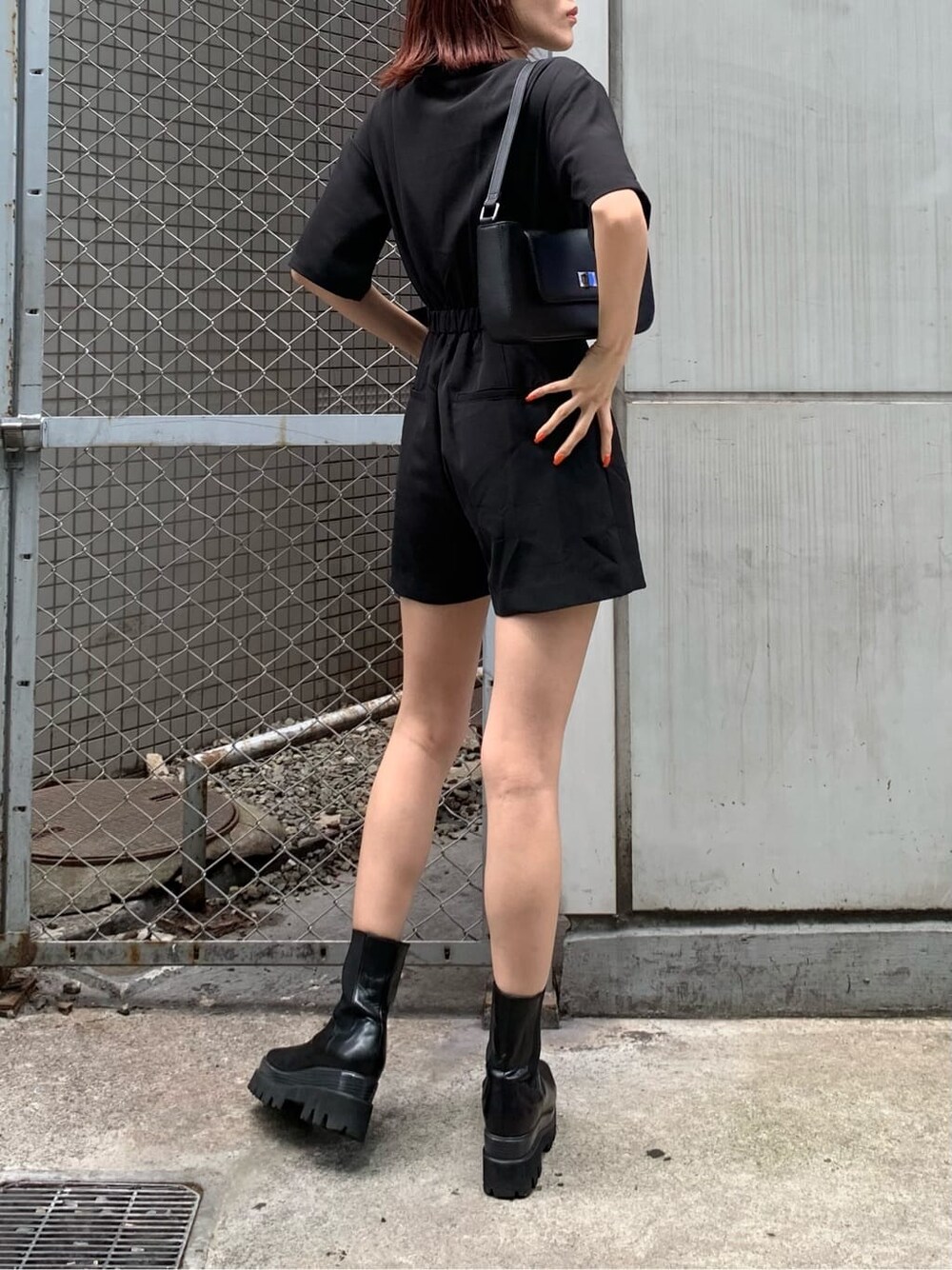 ブラック系のブーツ、ブラック系のつなぎ/オールインワン、ブラック系のショルダーバッグを着用したレディースの春コーディネートの3枚目の写真