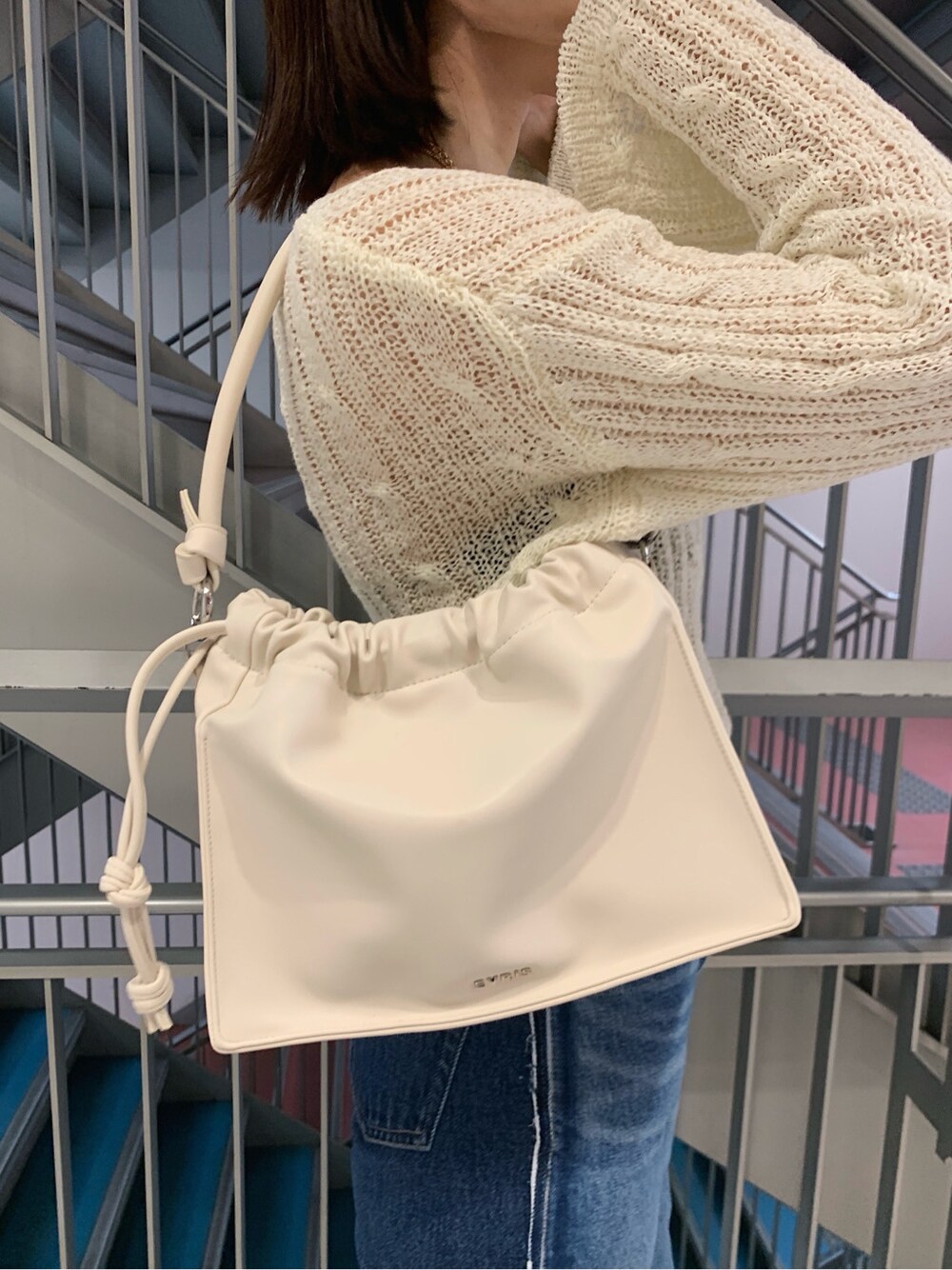 ホワイト系のニット/セーター、ベージュ系のパンプス、ホワイト系のショルダーバッグを着用したレディースの春コーディネートの7枚目の写真