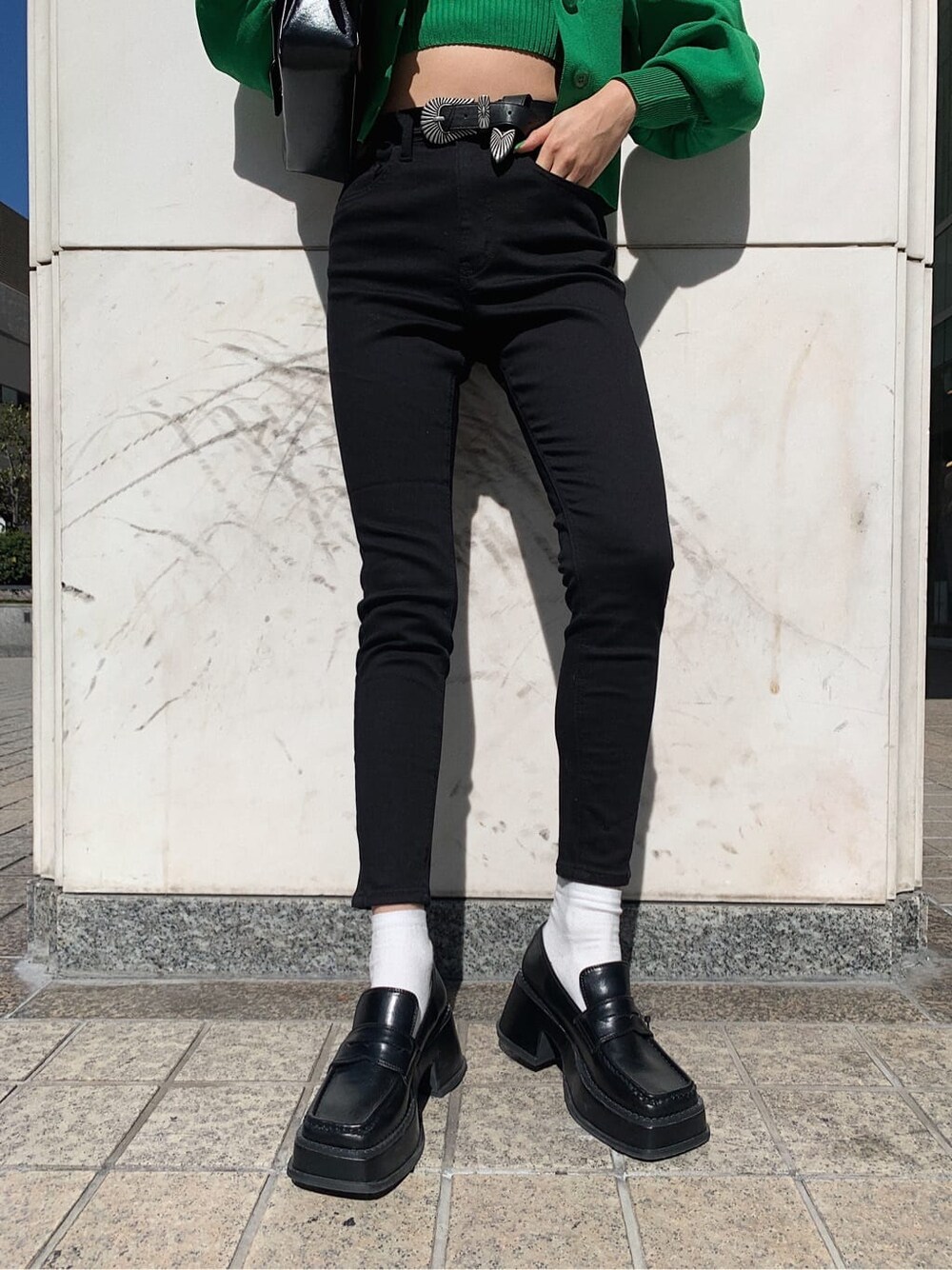 ブラック系のデニムパンツ、ブラック系のローファー、ブラック系のショルダーバッグを着用したレディースの春コーディネートの7枚目の写真