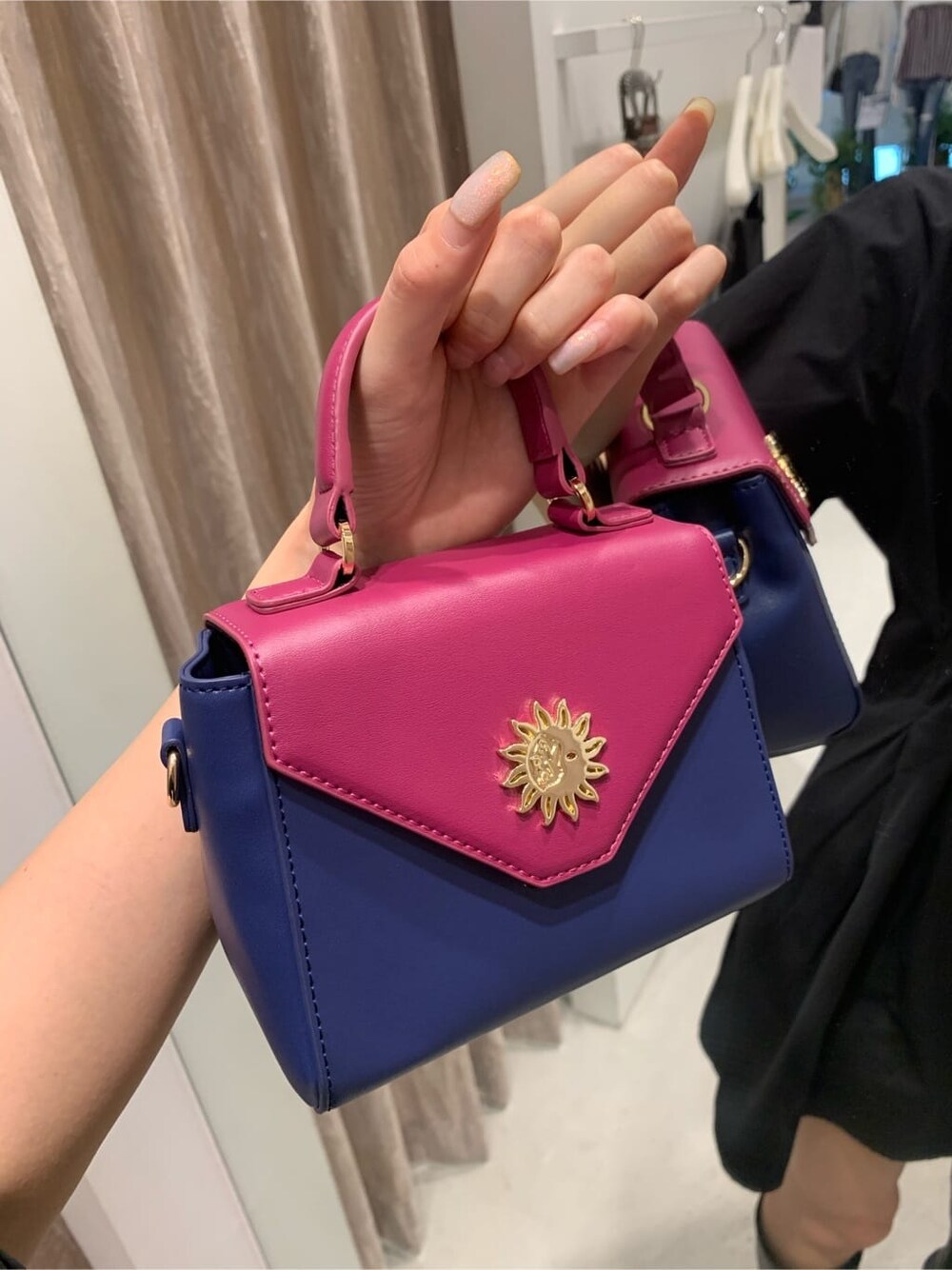 ブラック系のワンピース、ブラック系のブーツ、ブルー系のショルダーバッグを着用したレディースの夏コーディネートの6枚目の写真