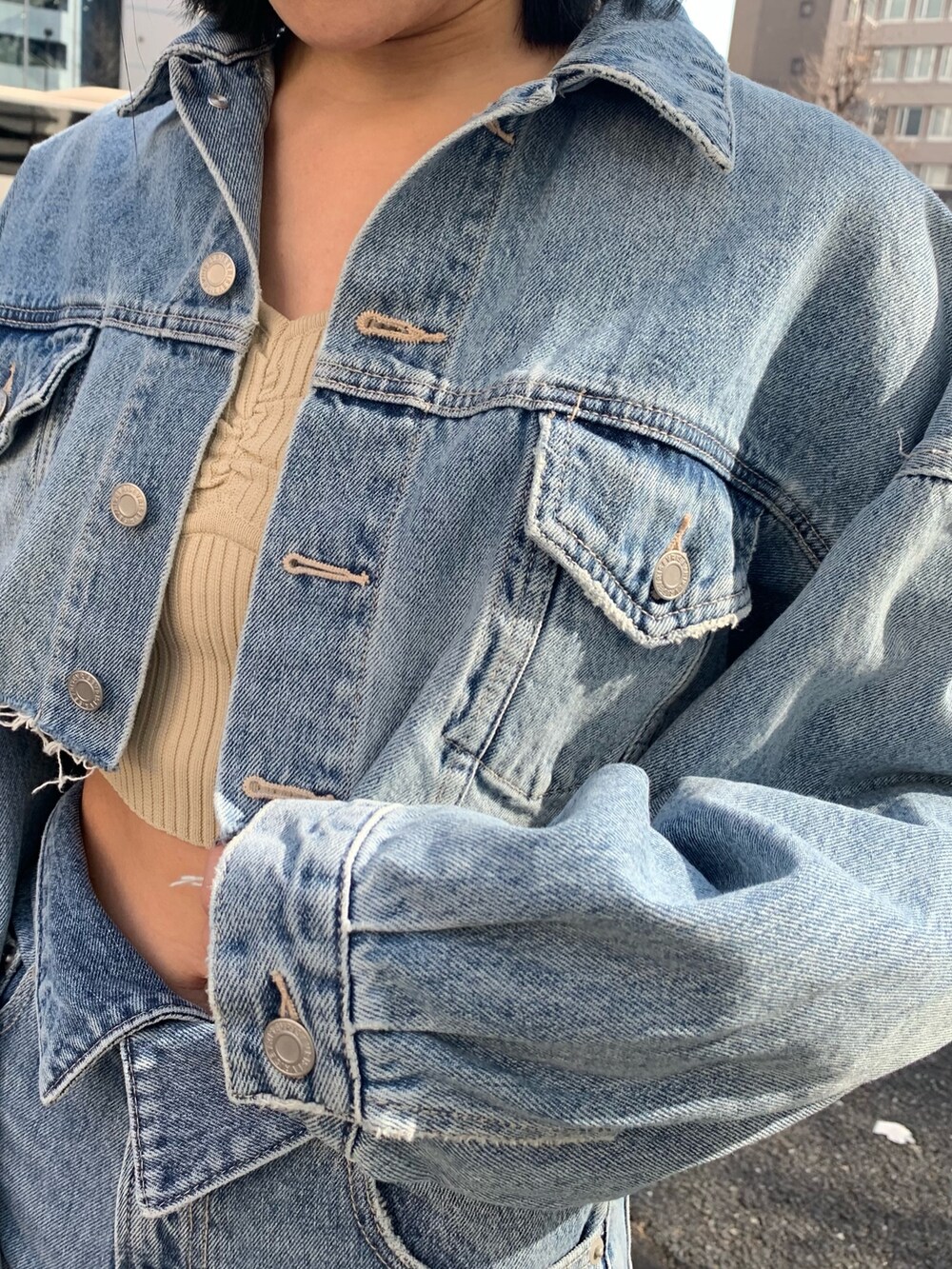 ブルー系のデニムパンツ、ブルー系のデニムジャケット、ホワイト系のカーディガン/ボレロを着用したレディースの冬コーディネートの6枚目の写真