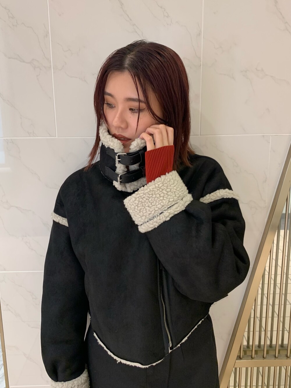 レッド系のニット/セーター、ブラック系のムートンコート、ブラック系のその他パンツを着用したレディースの夏コーディネートの5枚目の写真
