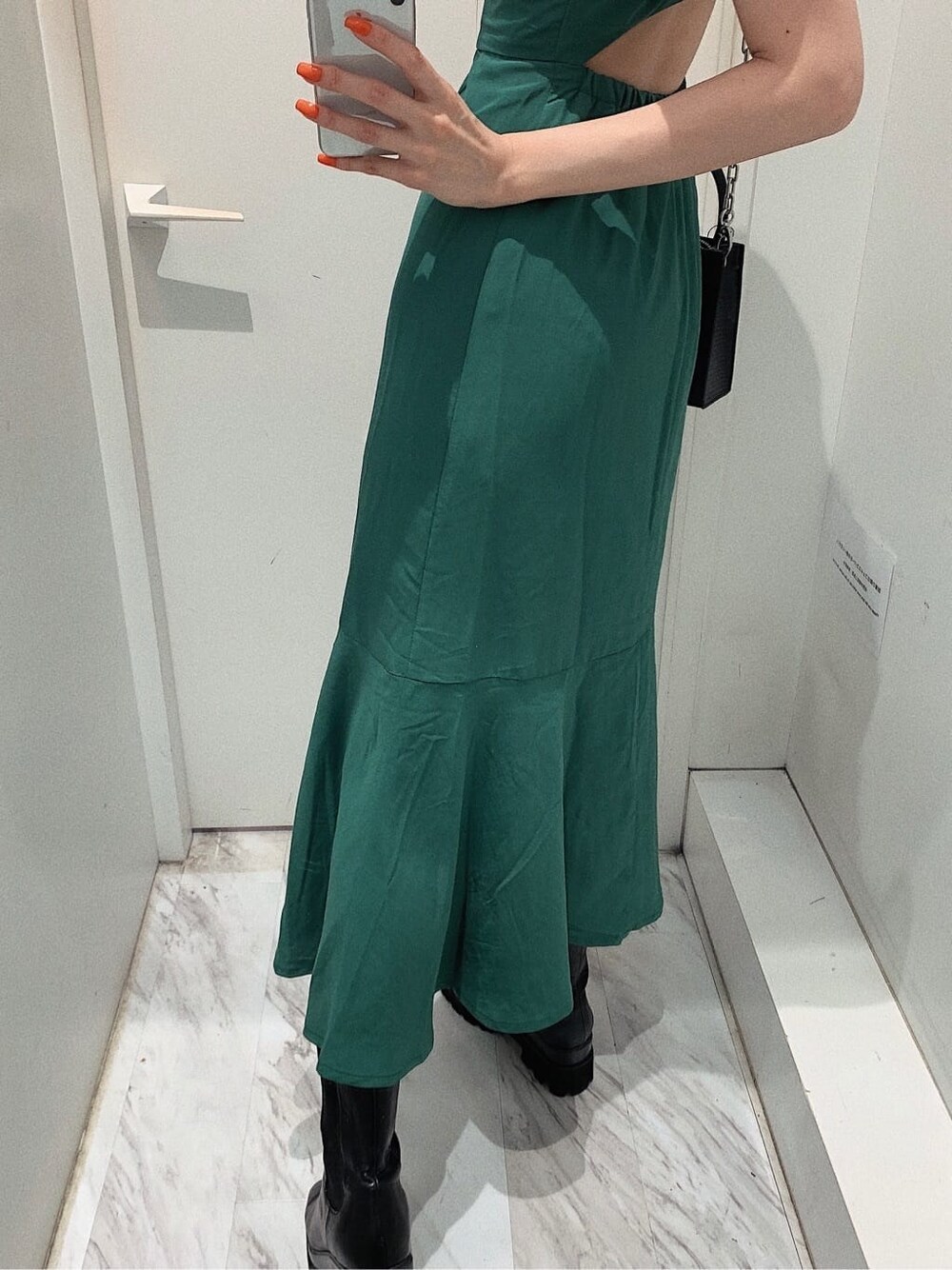 ブラック系のブーツ、ブラック系のショルダーバッグ、グリーン系のワンピースを着用したレディースの春コーディネートの6枚目の写真