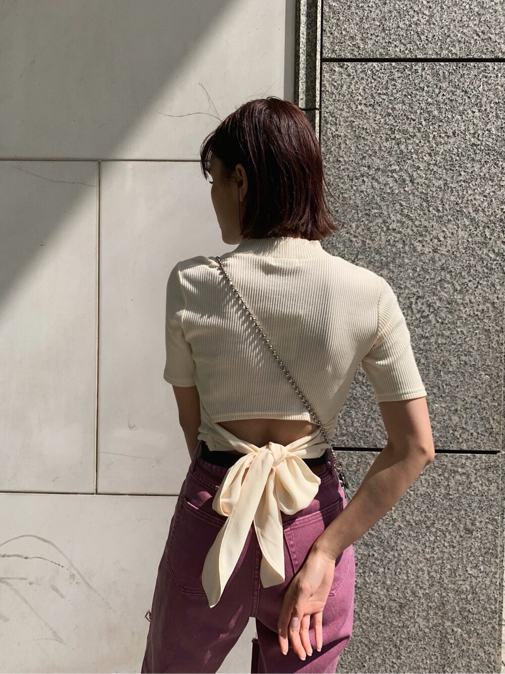 ブラック系のサンダル、パープル系のデニムパンツ、ホワイト系のTシャツ/カットソーを着用したレディースの春コーディネートの6枚目の写真