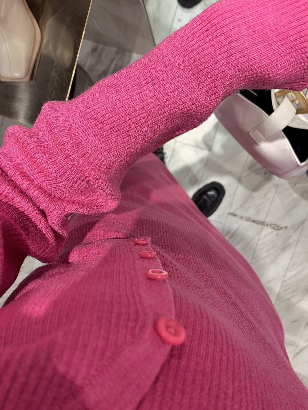 ホワイト系のハンドバッグ、ピンク系のワンピース、ブラック系のブーツを着用したレディースの冬コーディネートの5枚目の写真