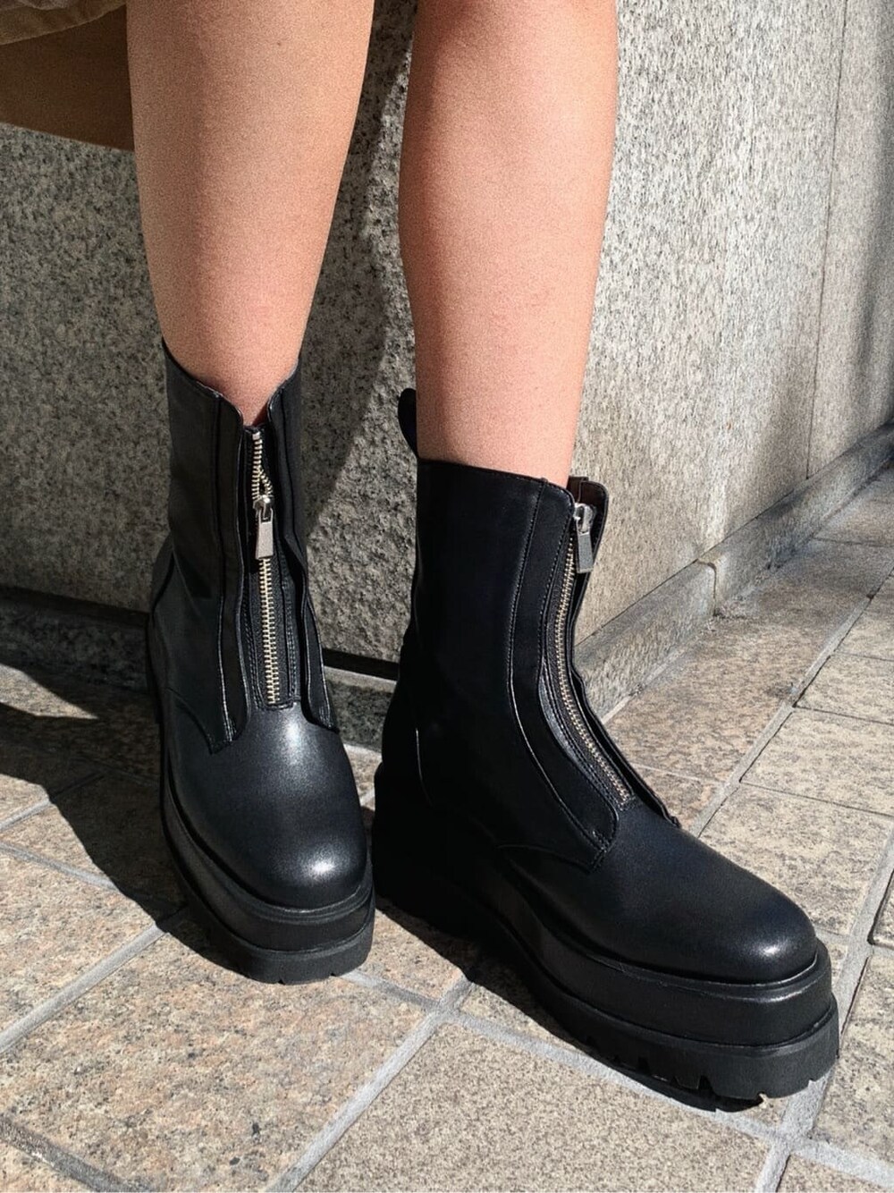 ベージュ系のスカート、ブラック系のブーツ、ブラック系のニット/セーターを着用したレディースの冬コーディネートの8枚目の写真