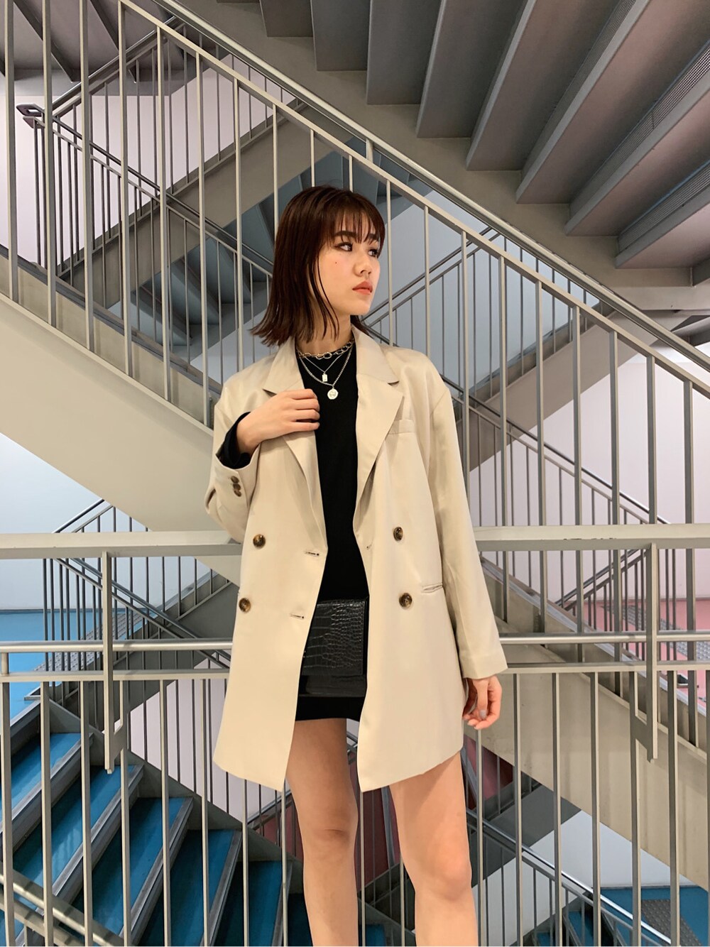 グレー系のテーラードジャケット、ブラック系のTシャツ/カットソー、ブラック系のスカートを着用したレディースの冬コーディネートの6枚目の写真