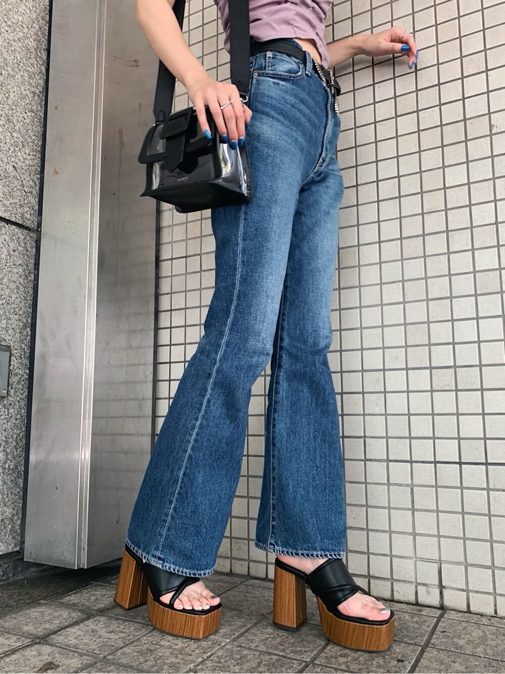 ブルー系のデニムパンツ、ブラック系のサンダル、ブラック系のベルトを着用したレディースの夏コーディネートの6枚目の写真