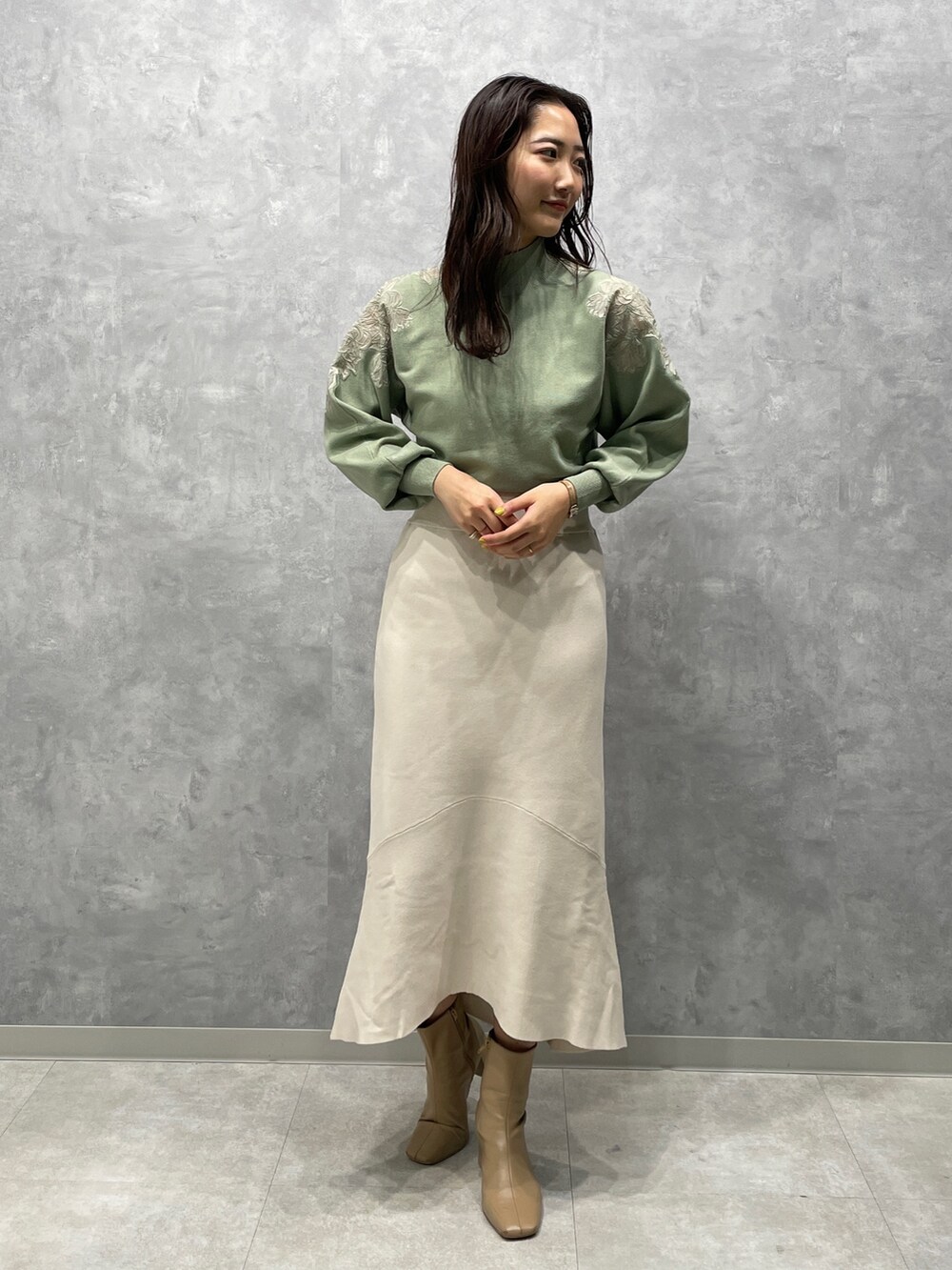 ベージュ系のブーツ、グリーン系のニット/セーター、ベージュ系のその他アウターを着用したレディースの冬コーディネートの5枚目の写真