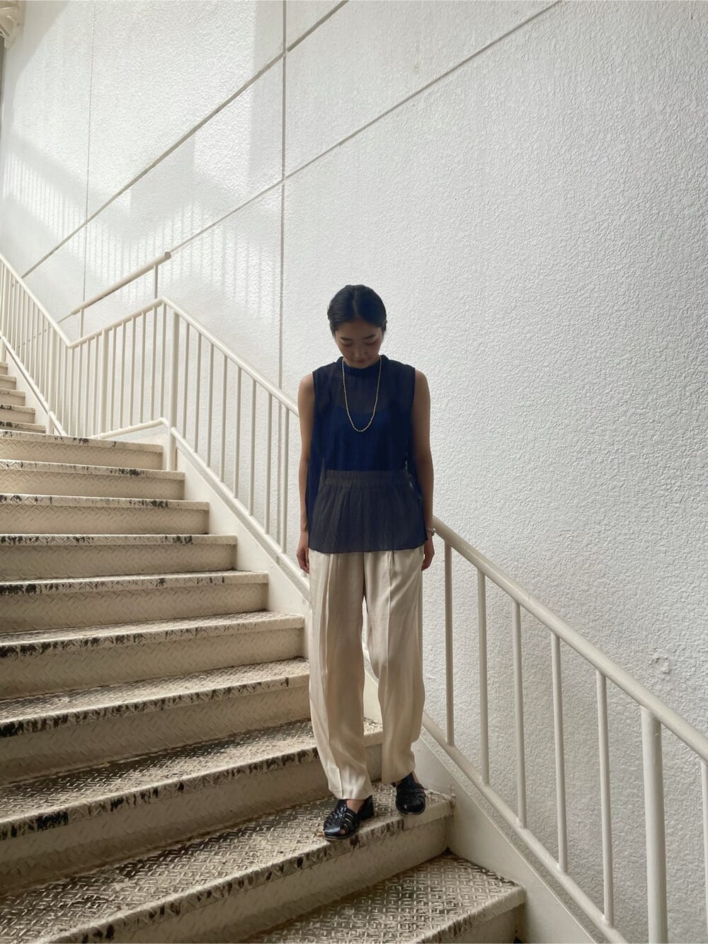 ホワイト系のその他パンツ、ブルー系のシャツ/ブラウス、ゴールド系のネックレスを着用したレディースの夏コーディネートの2枚目の写真