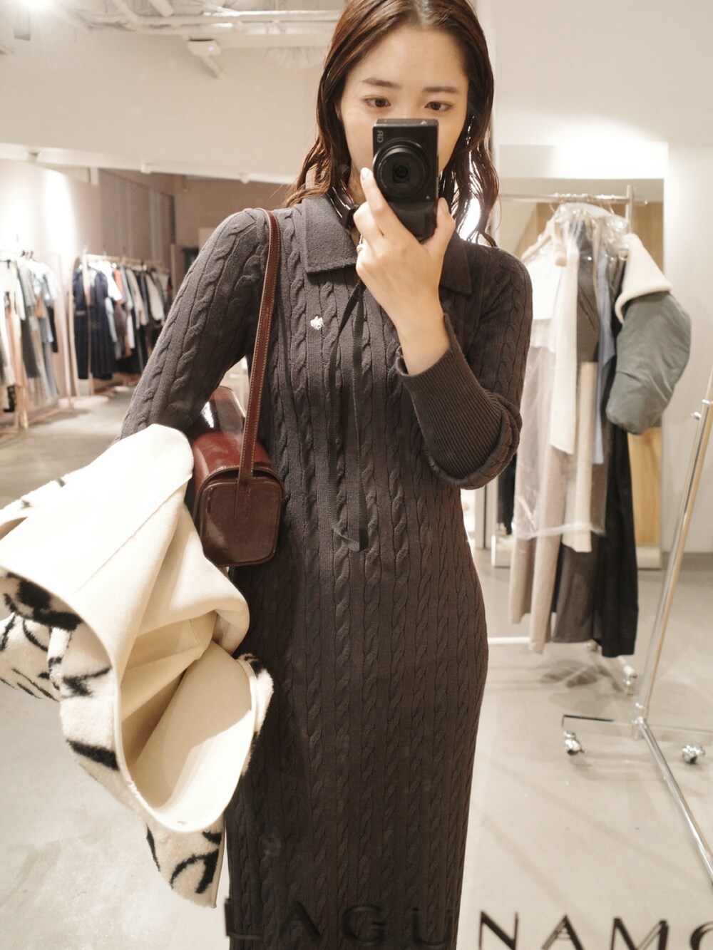 グレー系のワンピース、ホワイト系のブルゾン、ブラック系のブーツを着用したレディースの夏コーディネートの4枚目の写真