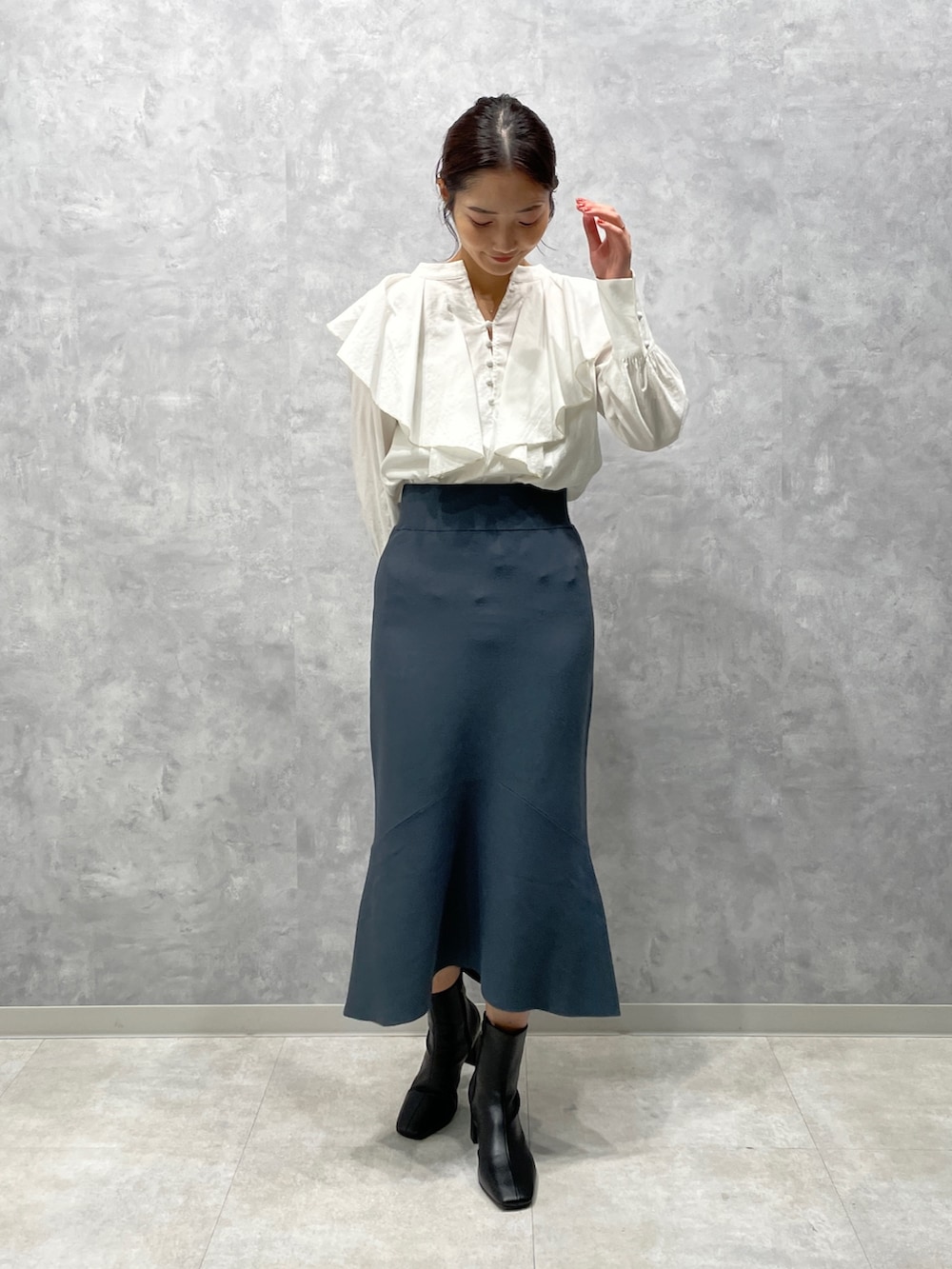 ホワイト系のカーディガン/ボレロ、ブラック系のブーツ、グリーン系のスカートを着用したレディースの冬コーディネートの5枚目の写真