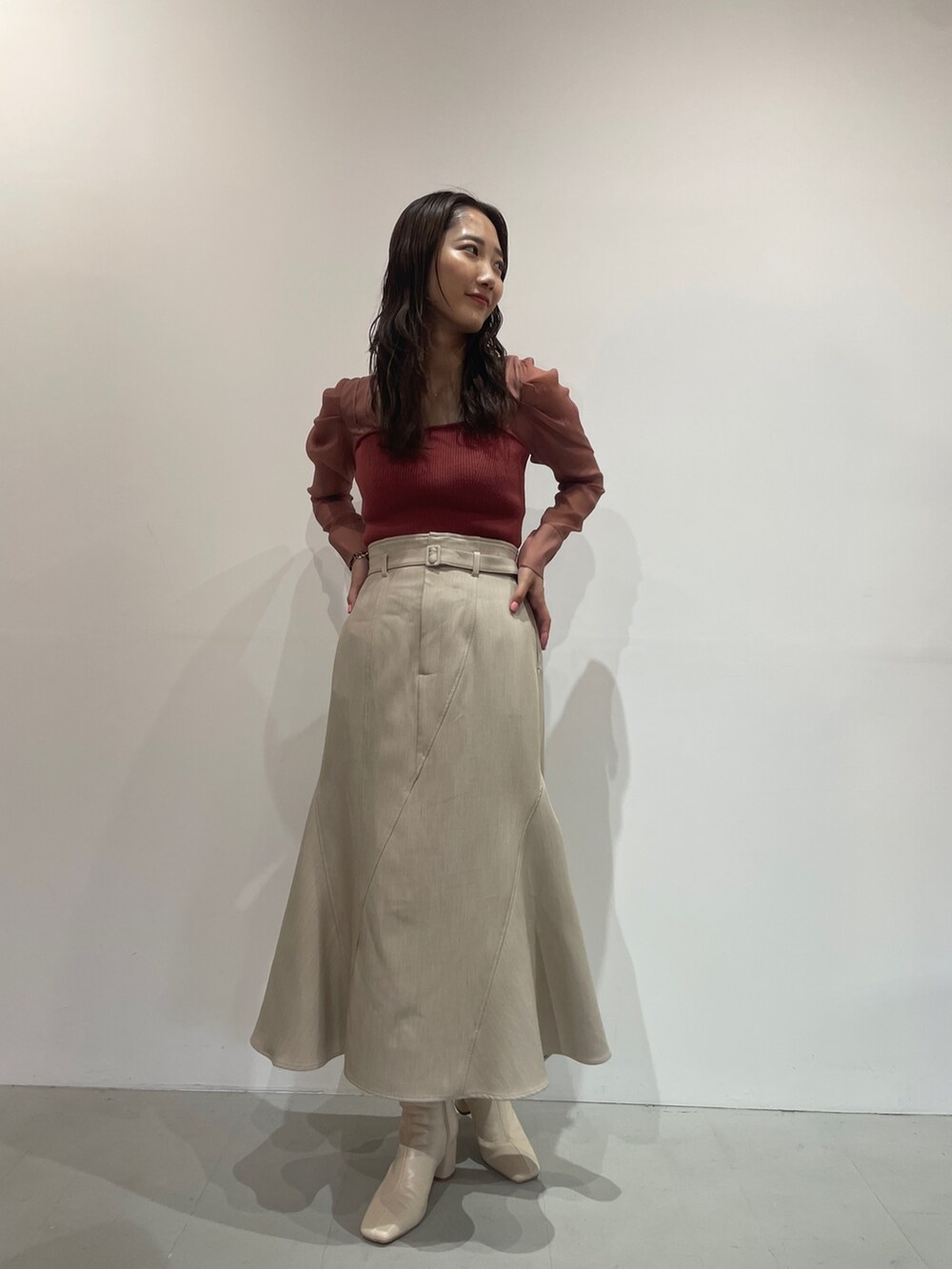 ホワイト系のブーツ、ベージュ系のスカート、ピンク系のニット/セーターを着用したレディースの夏コーディネートの3枚目の写真