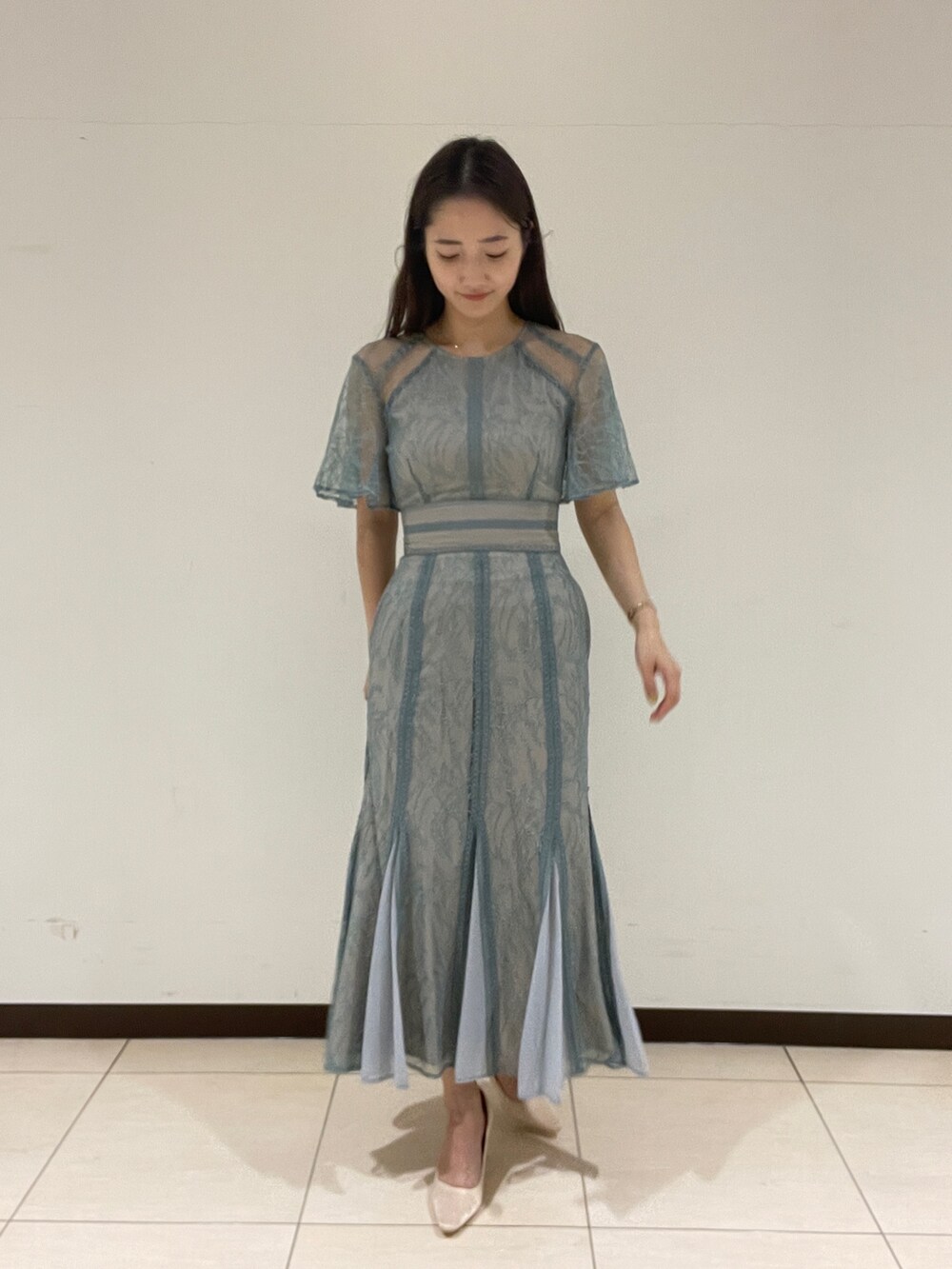 グリーン系のドレス、ベージュ系のパンプスを着用したレディースの春コーディネートの5枚目の写真