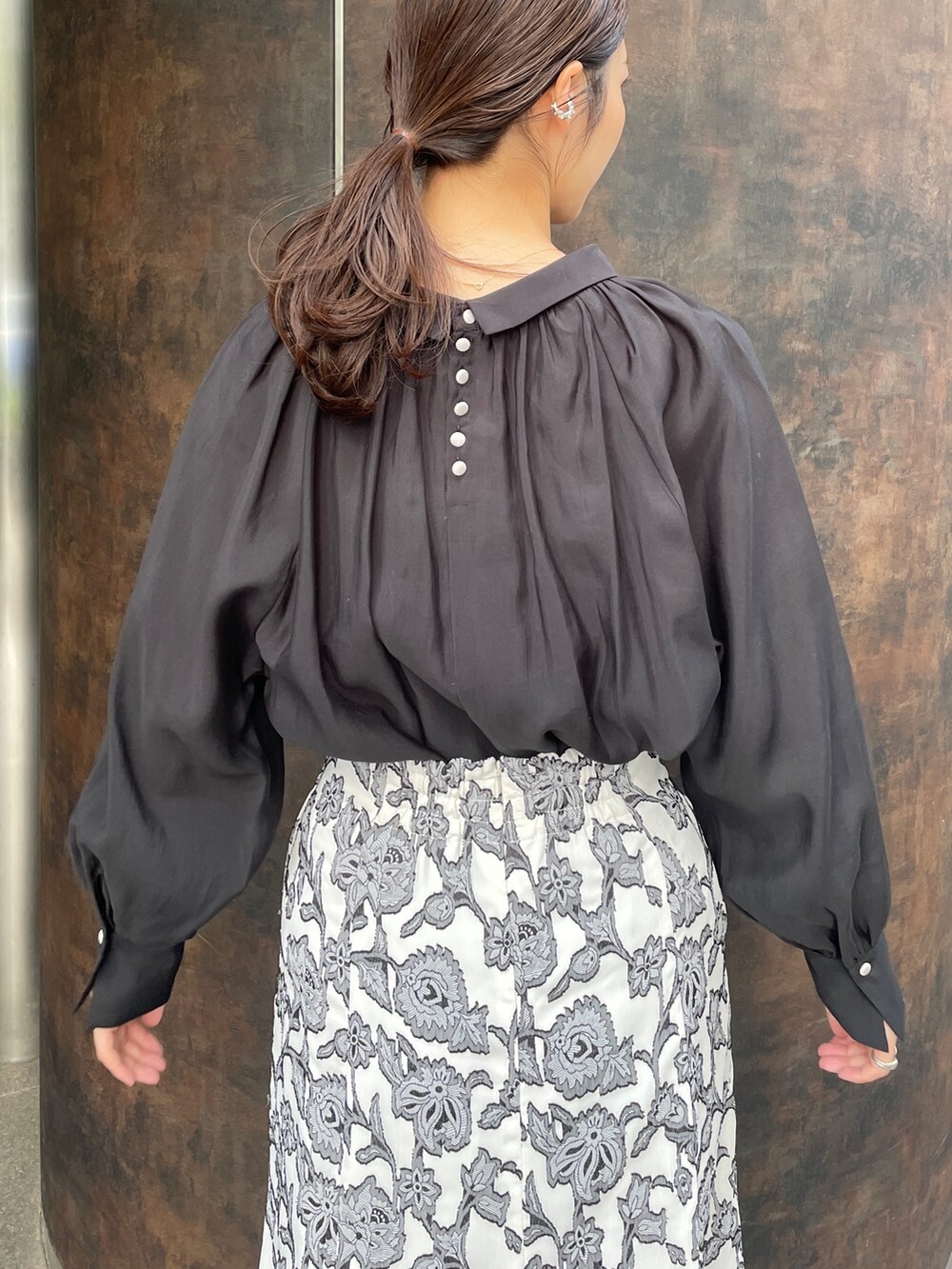 ベージュ系のサンダル、ブラック系のスカート、ブラック系のシャツ/ブラウスを着用したレディースの冬コーディネートの8枚目の写真