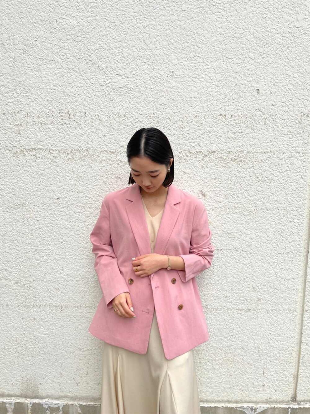 ホワイト系のスカート、ベージュ系のブーツ、ピンク系のテーラードジャケットを着用したレディースの春コーディネートの7枚目の写真