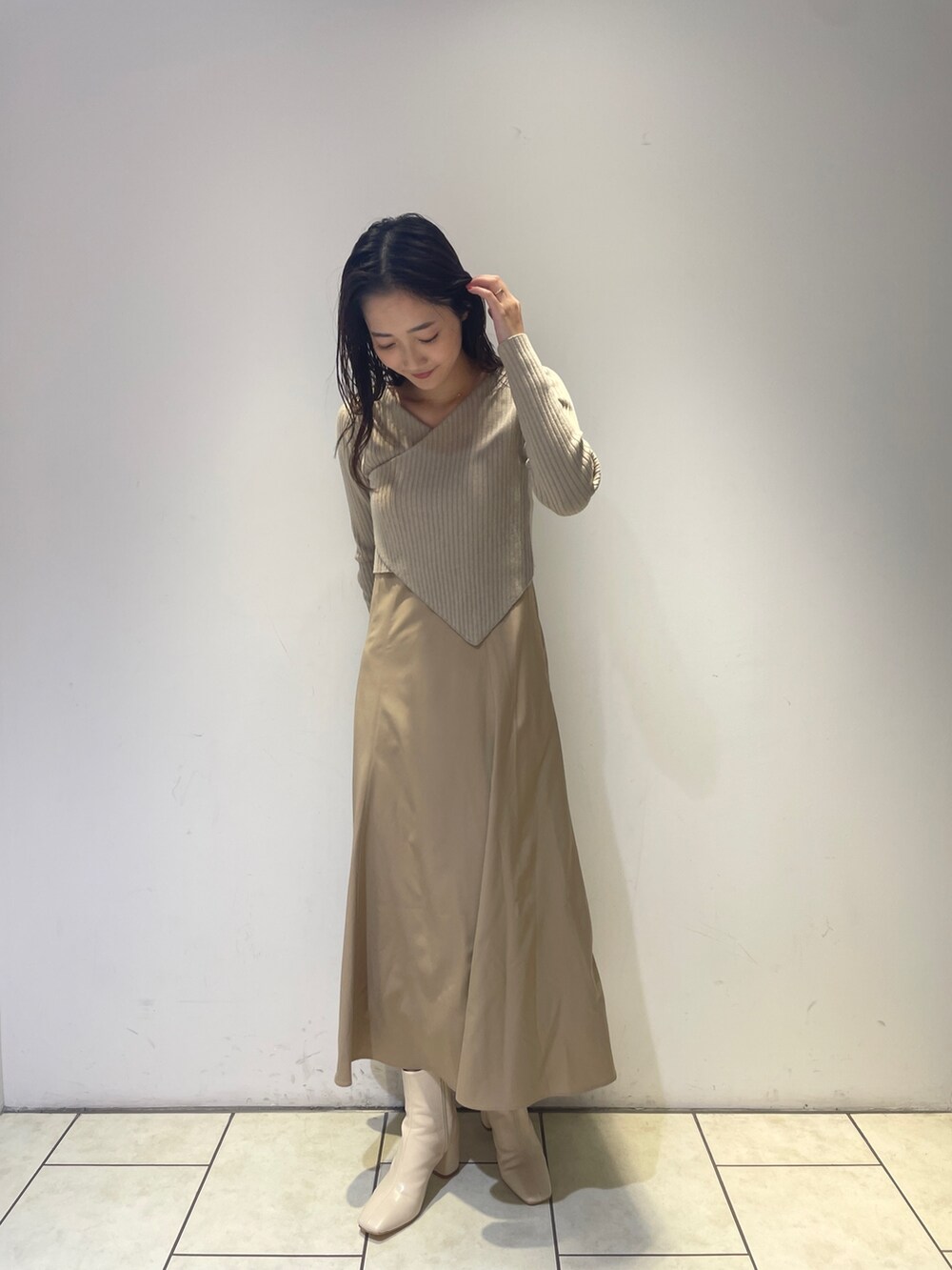 ベージュ系のワンピース、ホワイト系のブーツを着用したレディースの秋コーディネートの5枚目の写真