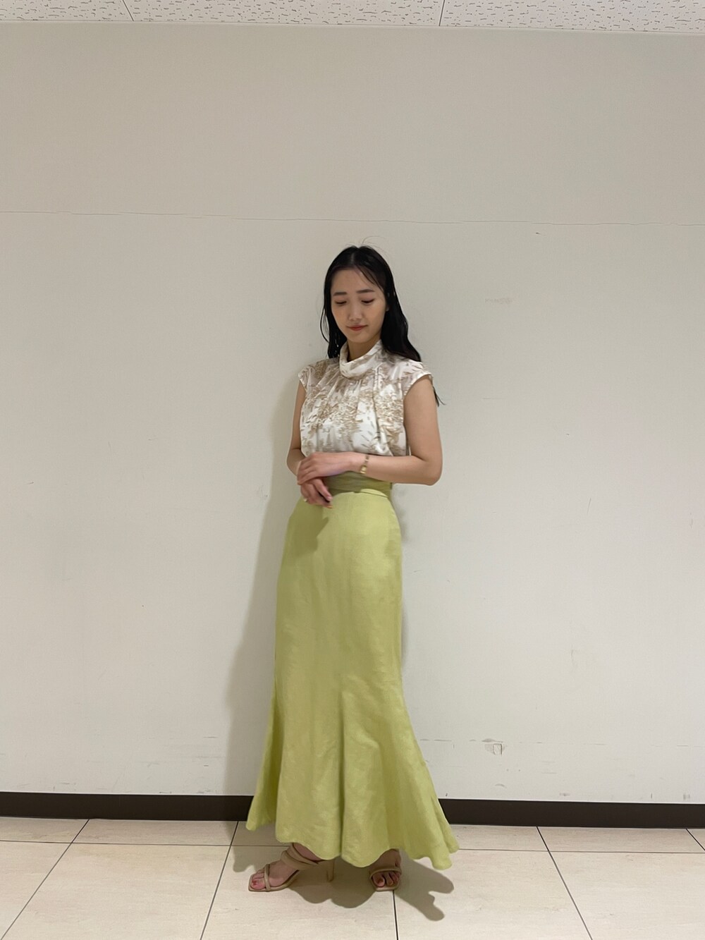 ベージュ系のシャツ/ブラウス、グリーン系のスカート、ベージュ系のサンダルを着用したレディースの春コーディネートの5枚目の写真