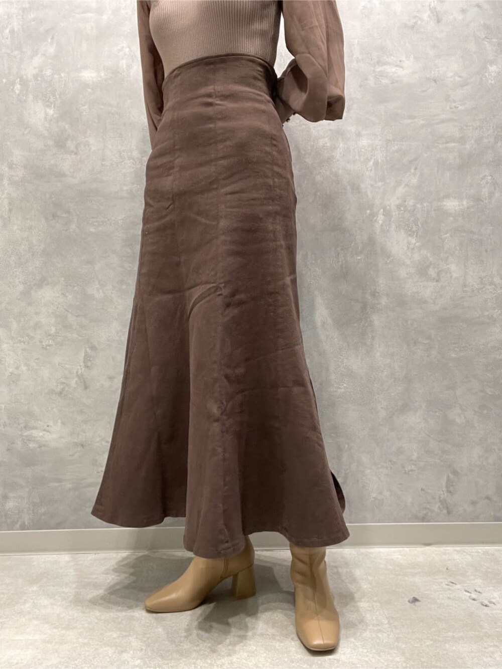 ベージュ系のブーツ、ブラウン系のスカート、ベージュ系のニット/セーターを着用したレディースの秋コーディネートの8枚目の写真