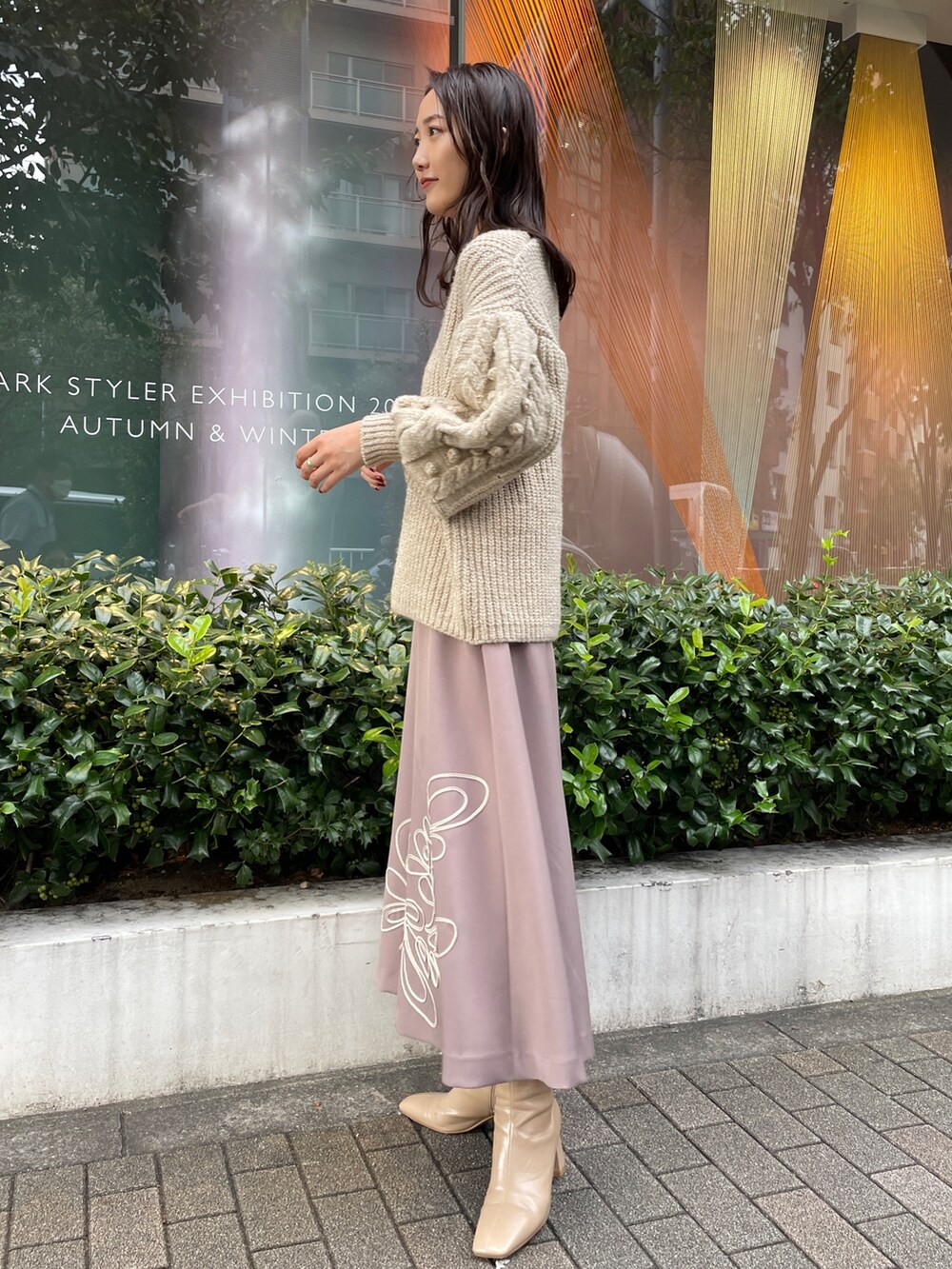 ホワイト系のニット/セーター、ホワイト系のその他アウター、ベージュ系のスカートを着用したレディースの秋コーディネートの6枚目の写真