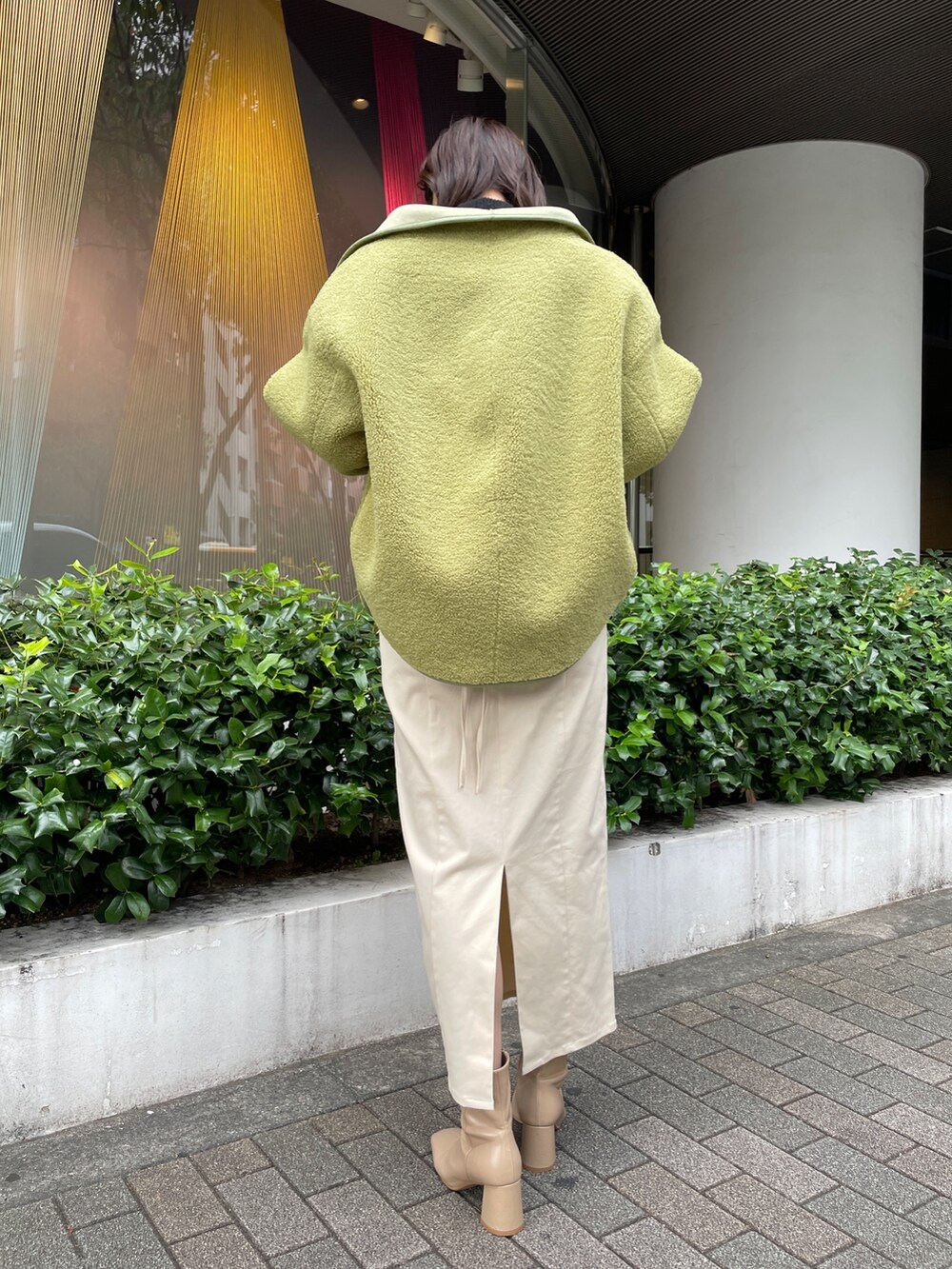 ベージュ系のブーツ、ブラック系のニット/セーター、ホワイト系のスカートを着用したレディースの秋コーディネートの6枚目の写真