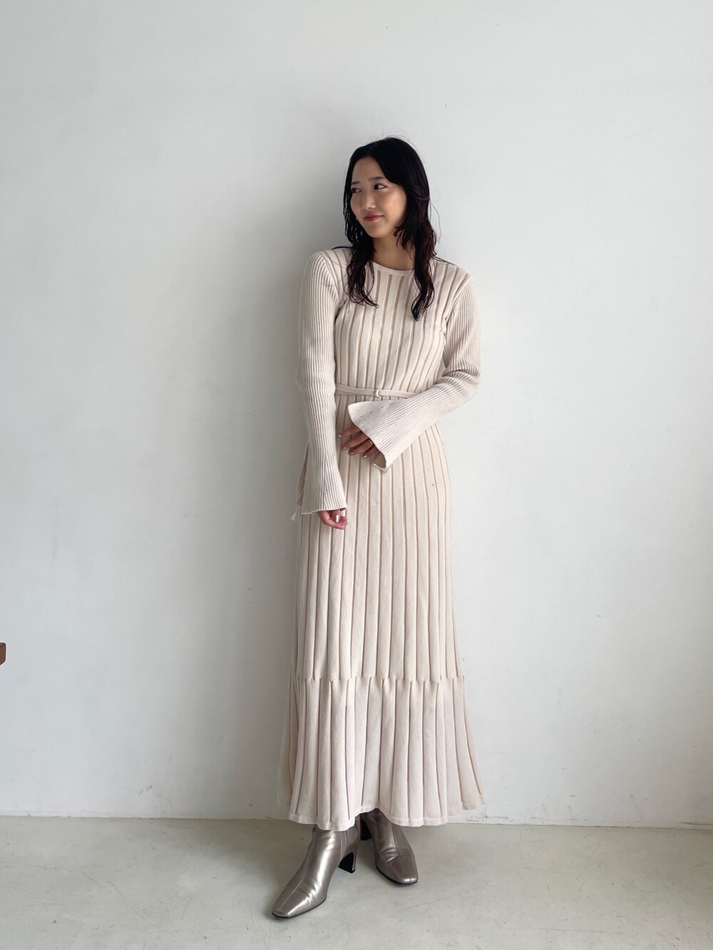 シルバー系のブーツ、ホワイト系のワンピースを着用したレディースの秋コーディネートの2枚目の写真