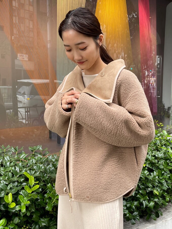 ベージュ系のブーツ、ブラウン系のブルゾン、ホワイト系のワンピースを着用したレディースの秋コーディネートの5枚目の写真