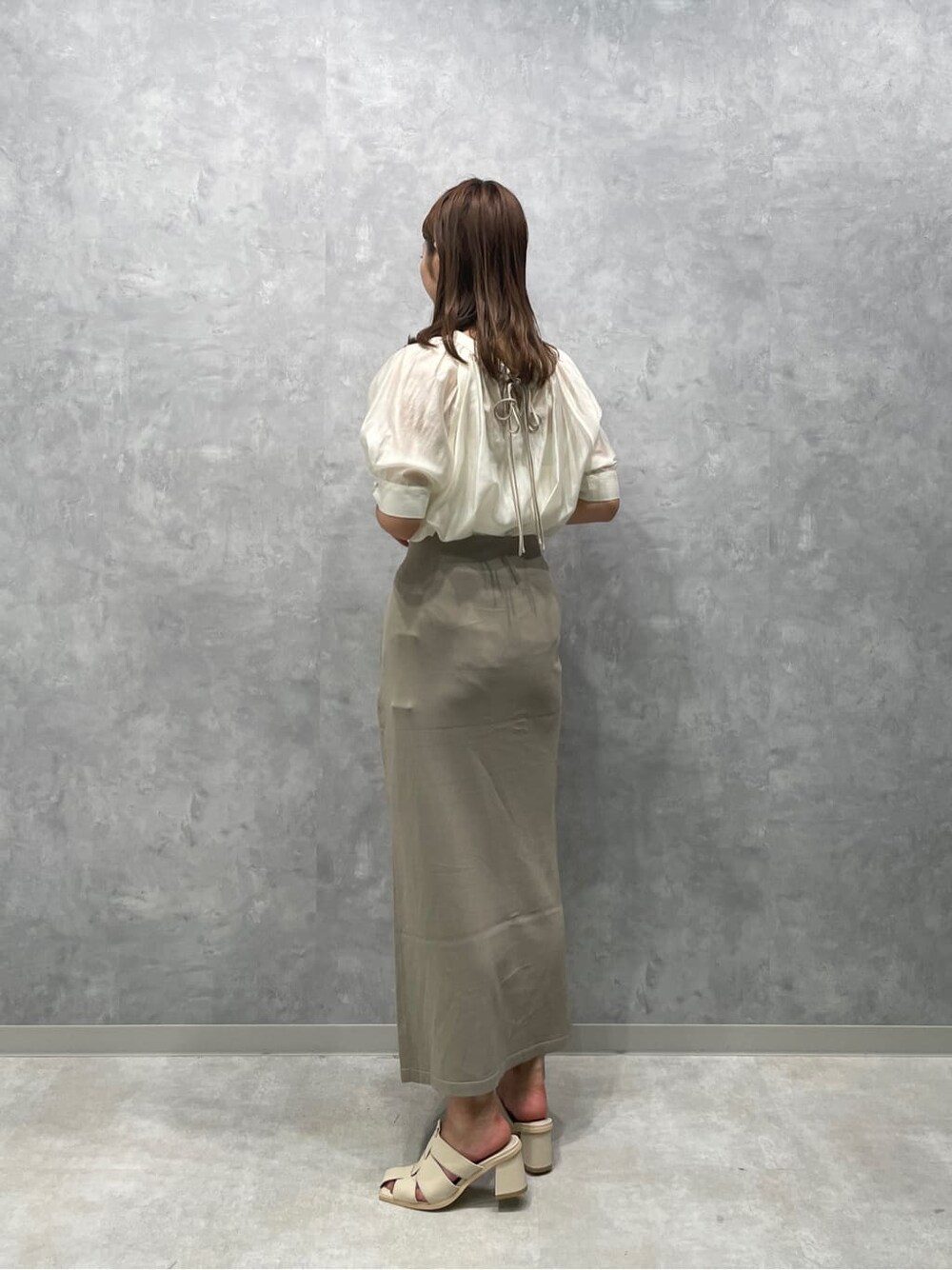 ホワイト系のサンダル、ベージュ系のスカート、ホワイト系のシャツ/ブラウスを着用したレディースの夏コーディネートの4枚目の写真