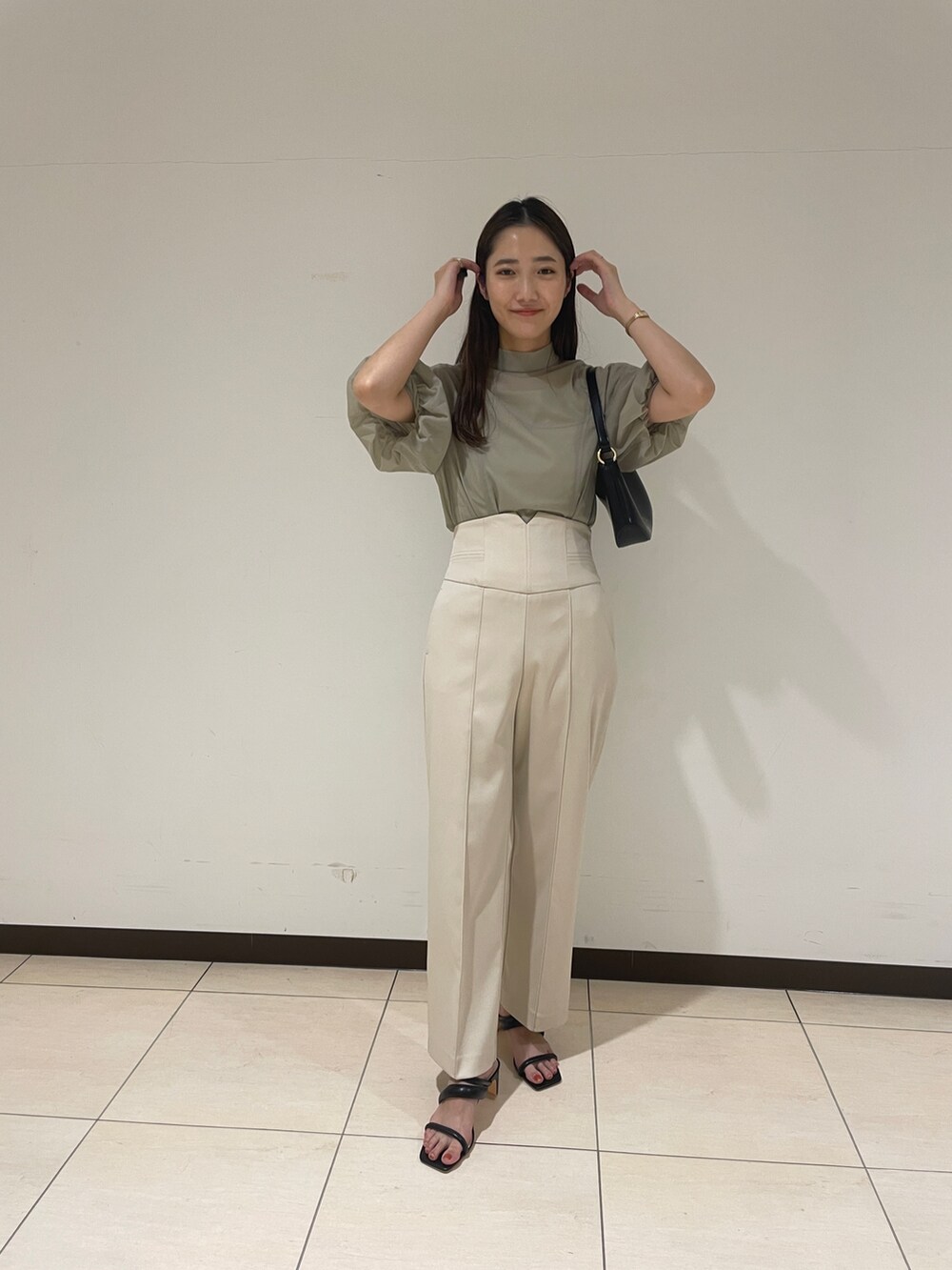 ホワイト系のその他パンツ、グリーン系のシャツ/ブラウス、ブラック系のハンドバッグを着用したレディースの春コーディネートの2枚目の写真