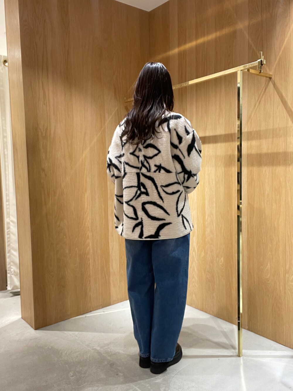 ブルー系のデニムパンツ、ホワイト系のブルゾン、グリーン系のニット/セーターを着用したレディースの秋コーディネートの3枚目の写真