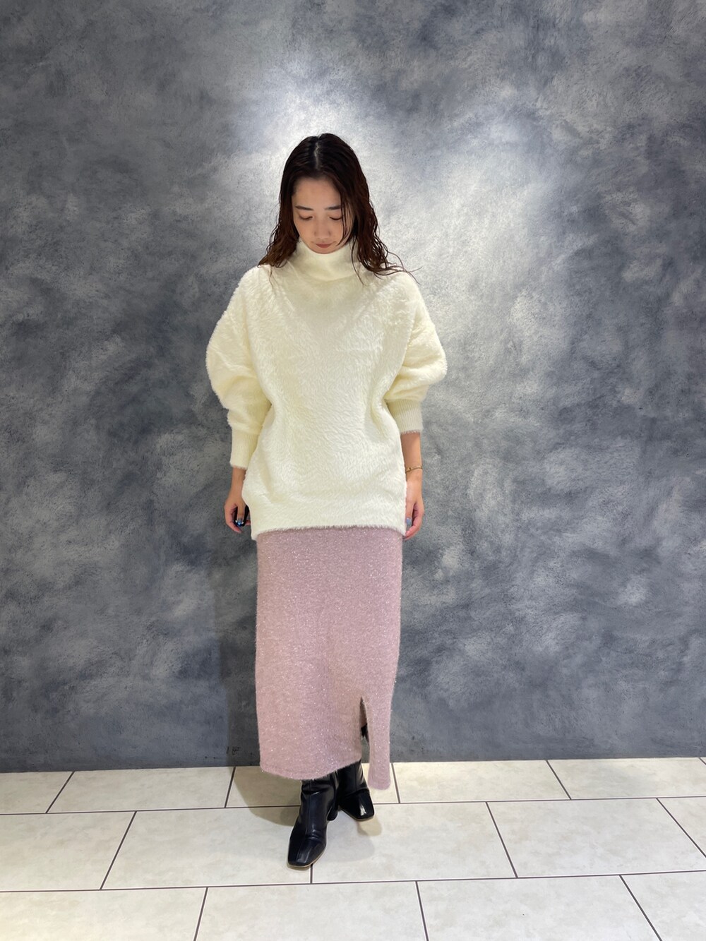 ホワイト系のニット/セーター、ピンク系のスカート、ブラック系のブーツを着用したレディースの秋コーディネートの4枚目の写真