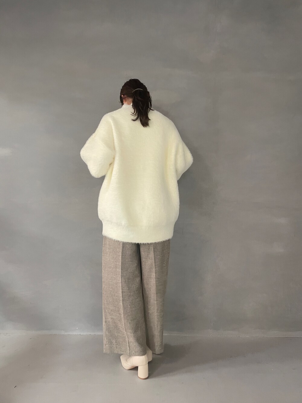 ホワイト系のニット/セーター、ベージュ系のその他パンツ、ホワイト系のブーツを着用したレディースの夏コーディネートの5枚目の写真