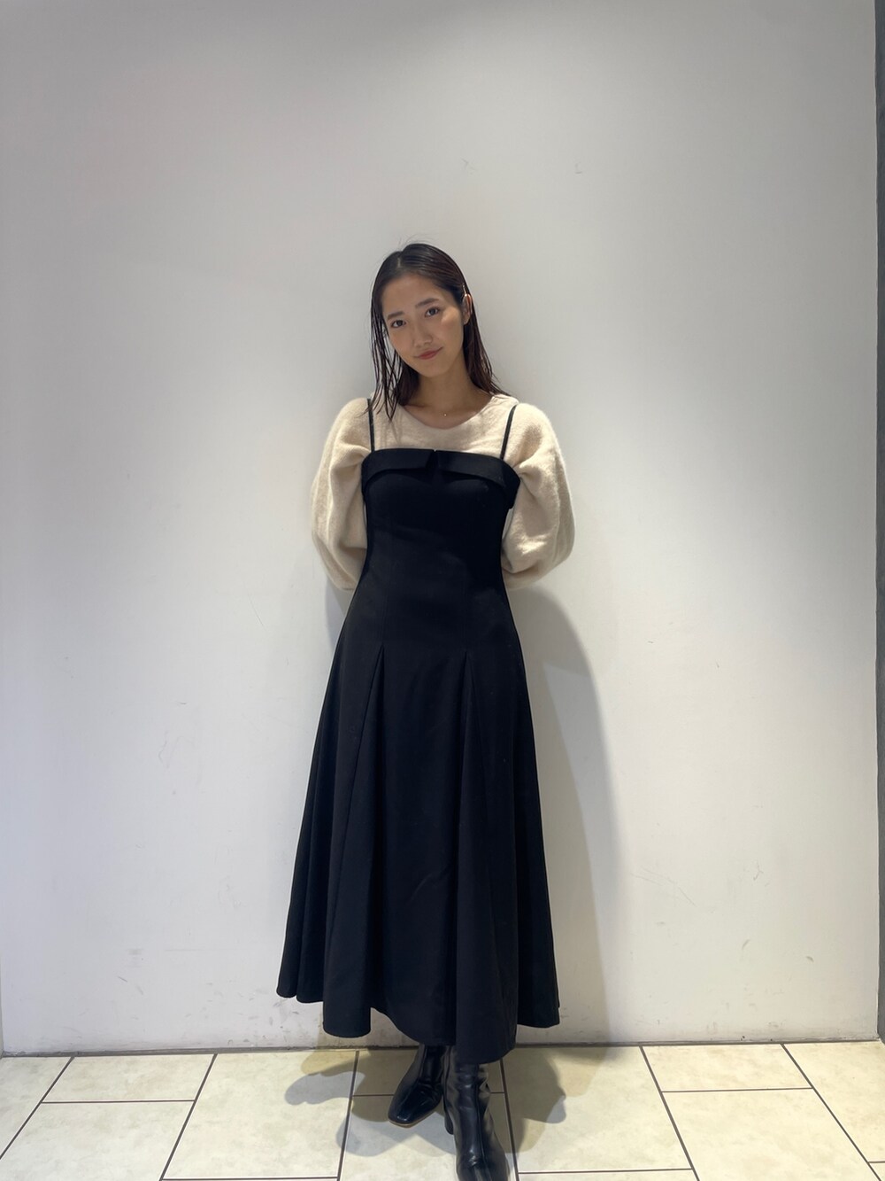 ホワイト系のニット/セーター、ブラック系のワンピース、ブラック系のブーツを着用したレディースの秋コーディネートの7枚目の写真