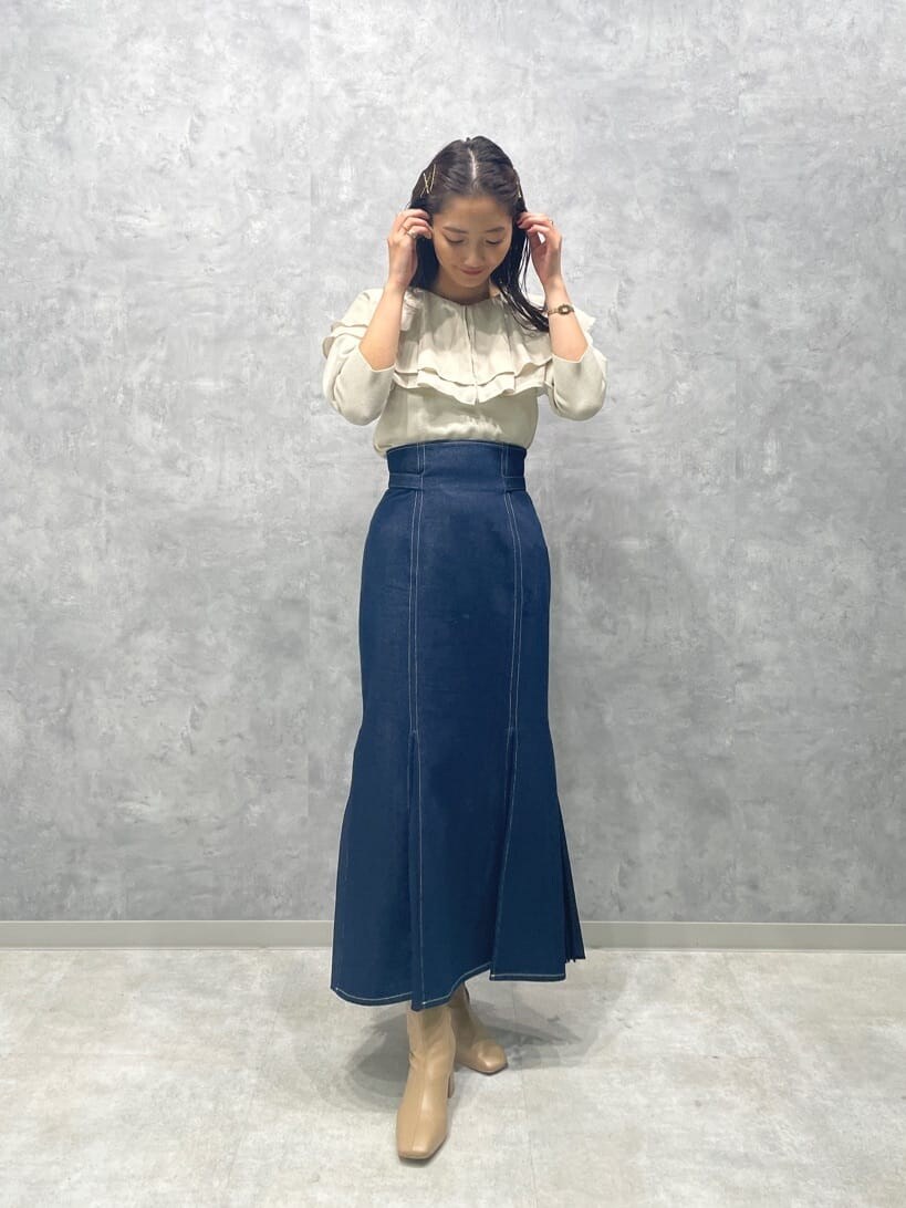 ベージュ系のブーツ、ブルー系のスカート、ホワイト系のニット/セーターを着用したレディースの秋コーディネートの4枚目の写真