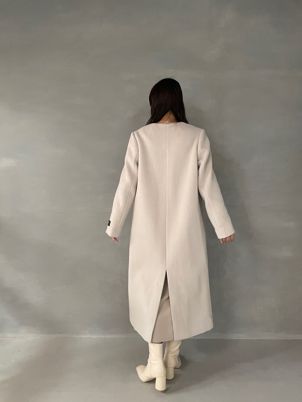 ホワイト系のブーツ、ピンク系のニット/セーター、ベージュ系のスカートを着用したレディースの秋コーディネートの3枚目の写真