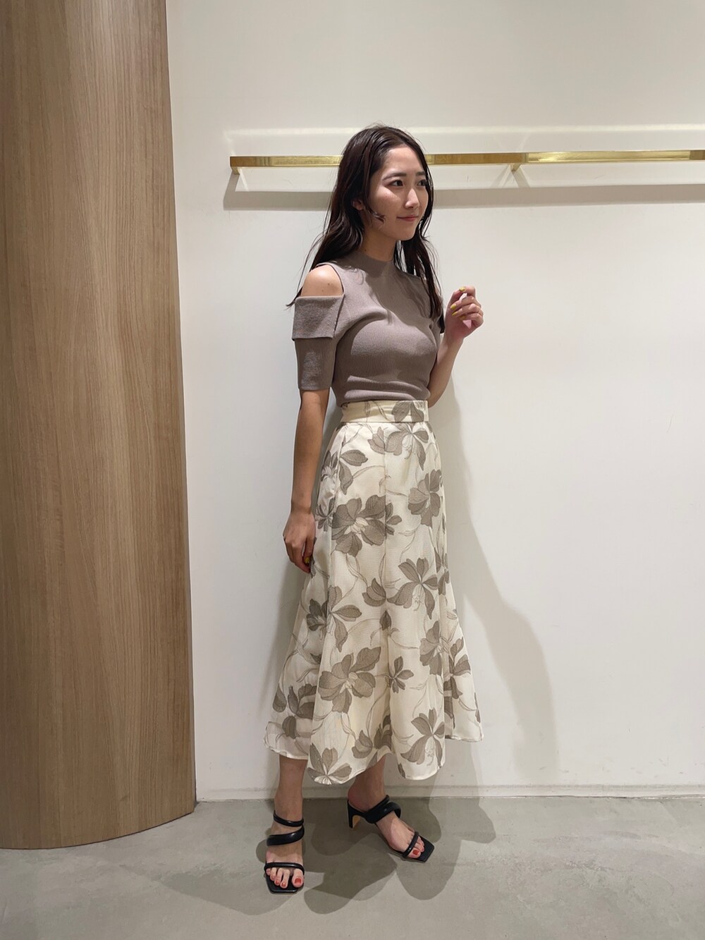 ベージュ系のスカート、ベージュ系のニット/セーター、ブラック系のサンダルを着用したレディースの春コーディネートの2枚目の写真