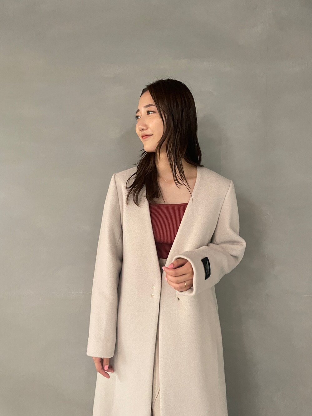 ホワイト系のブーツ、ピンク系のニット/セーター、ベージュ系のスカートを着用したレディースの秋コーディネートの4枚目の写真