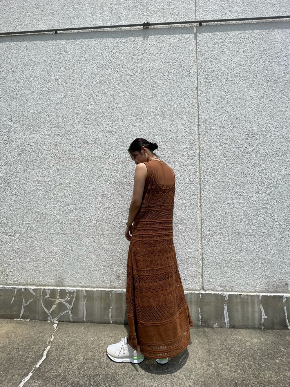 ブラウン系のワンピース、ホワイト系のスニーカー、シルバー系のブレスレットを着用したレディースの夏コーディネートの3枚目の写真