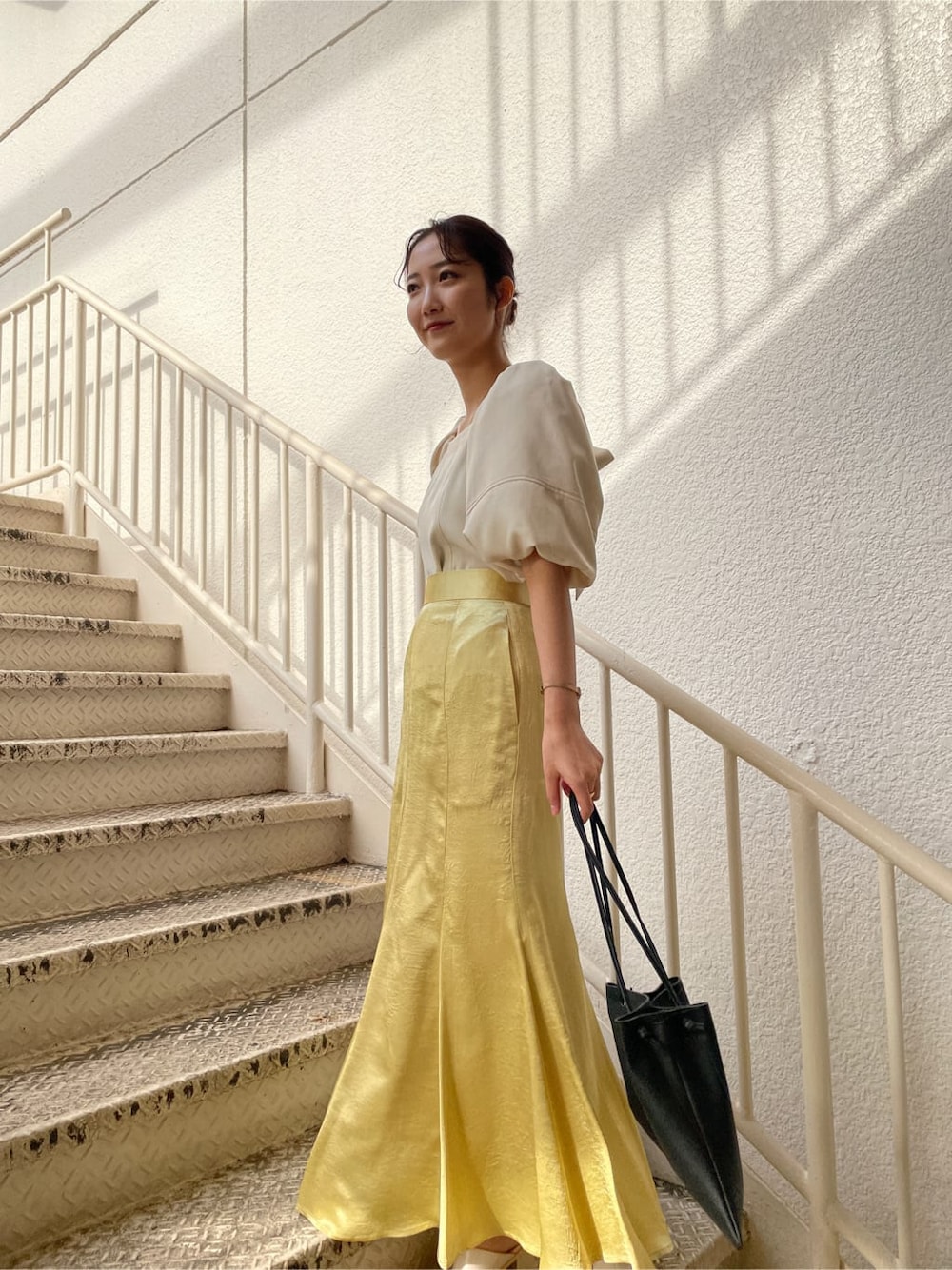 ホワイト系のシャツ/ブラウス、ホワイト系のテーラードジャケット、イエロー系のスカートを着用したレディースの冬コーディネートの5枚目の写真