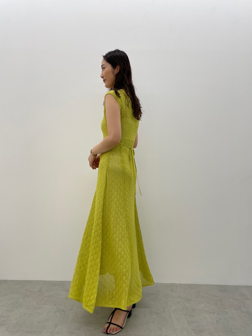 ブラック系のサンダル、グリーン系のワンピースを着用したレディースの春コーディネートの5枚目の写真