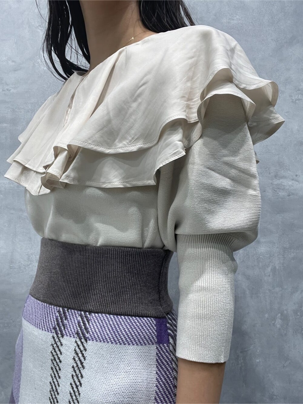 ベージュ系のブーツ、ホワイト系のニット/セーター、パープル系のスカートを着用したレディースの秋コーディネートの8枚目の写真