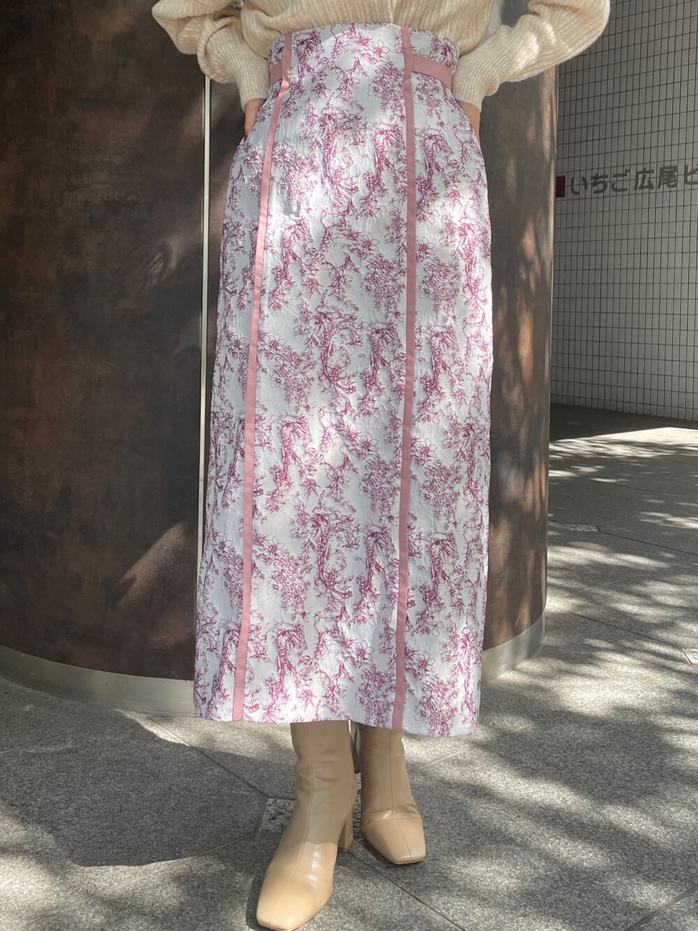 ホワイト系のニット/セーター、ベージュ系のブーツ、ピンク系のスカートを着用したレディースの秋コーディネートの9枚目の写真