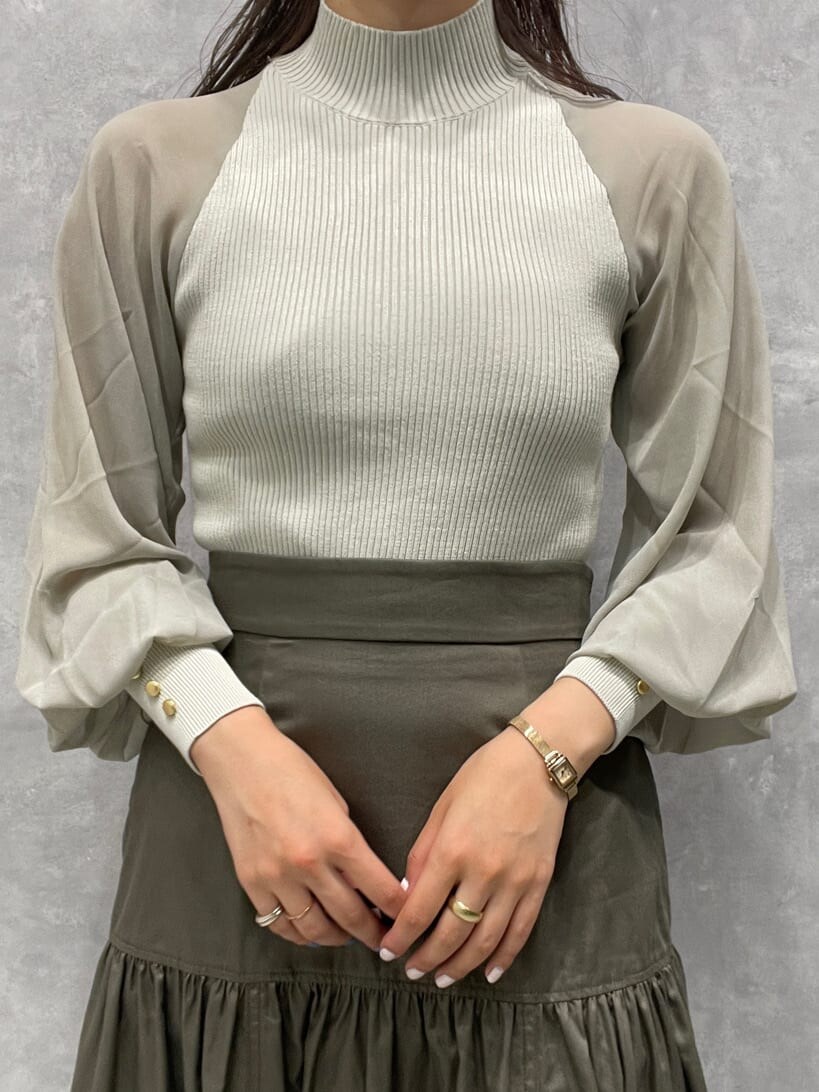 ベージュ系のスカート、ベージュ系のブーツ、グリーン系のニット/セーターを着用したレディースの夏コーディネートの7枚目の写真