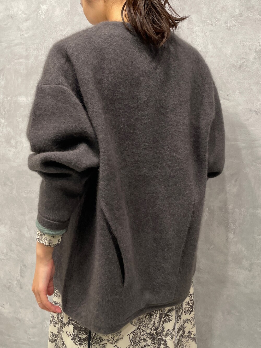 グレー系のカーディガン/ボレロ、ホワイト系のワンピース、ブラック系のブーツを着用したレディースの冬コーディネートの5枚目の写真